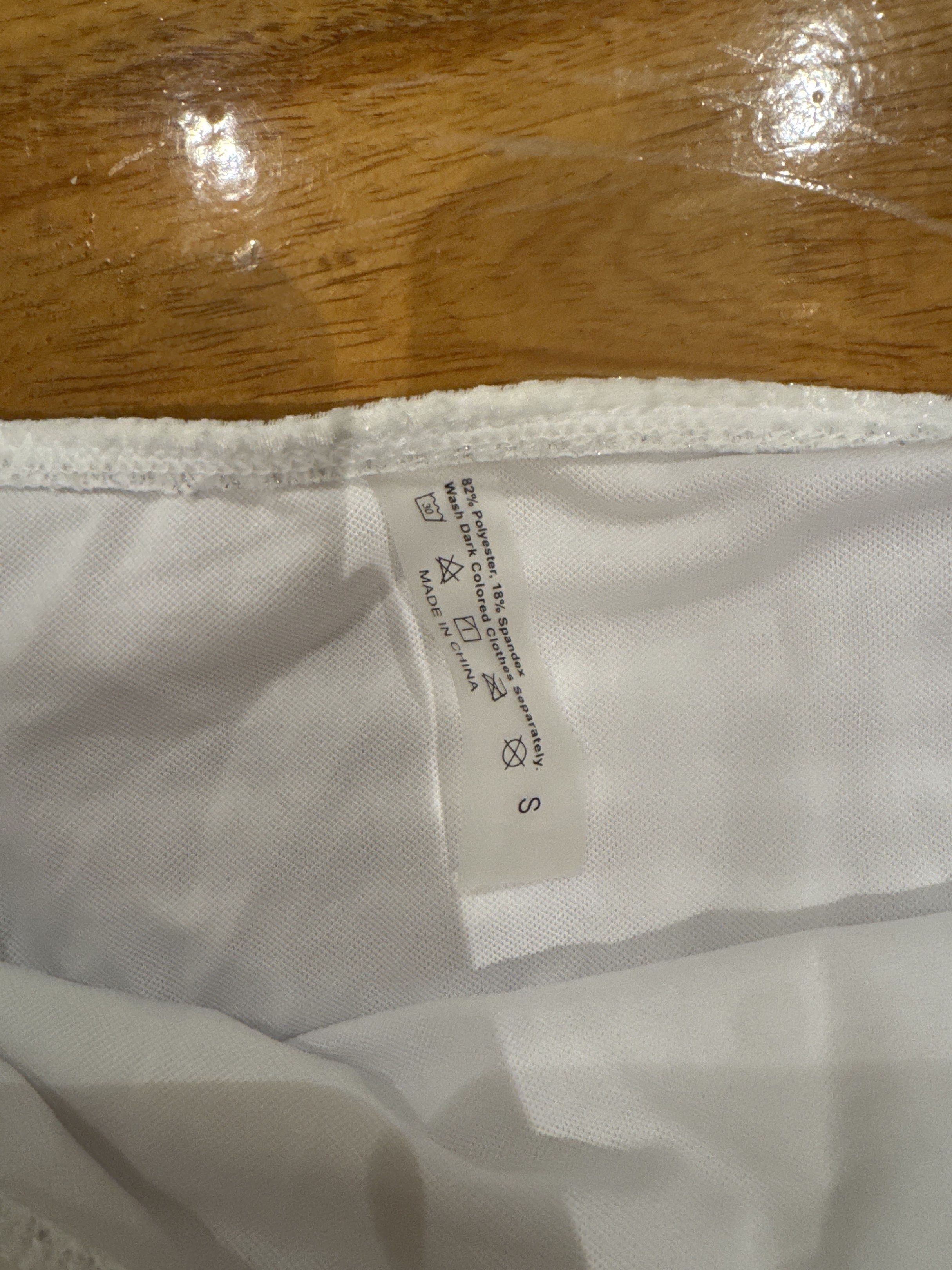 White Ruffled Mini Skirt (Category: Skirts) located in Manila. Submitted by eb.declutters (Listing ID 1417957309, Image 2). Description: - White mini skirt - Ruffled hem - Ruched design - Size S - Made in China - Material: 92% polyester, 8% spandex.