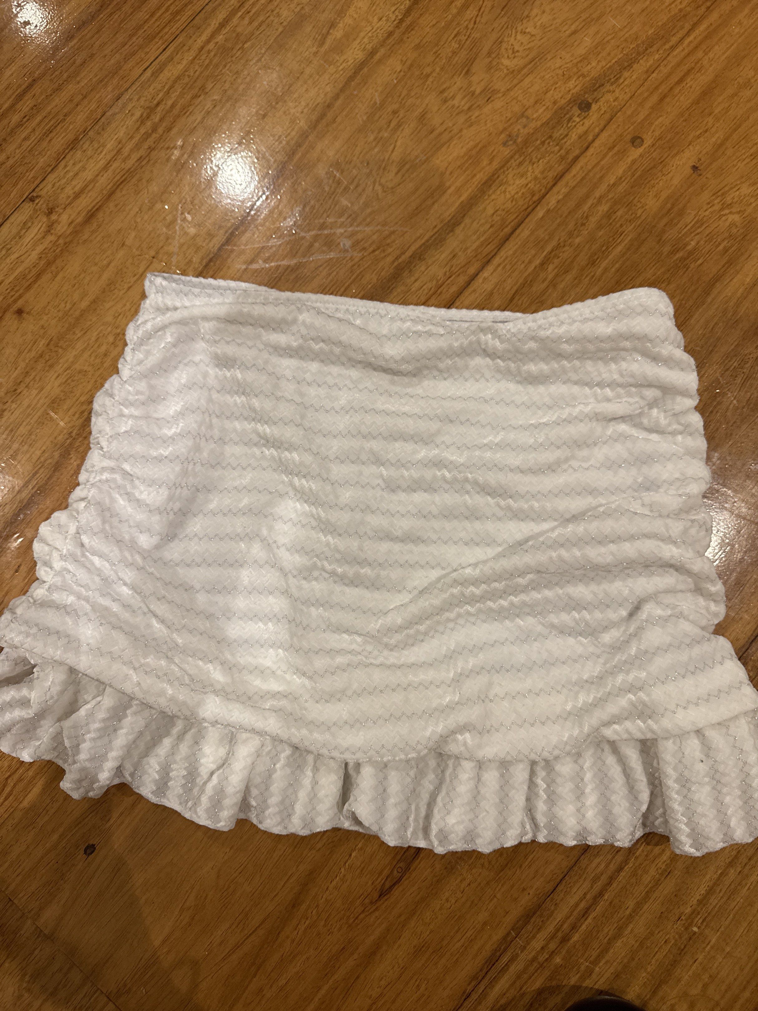 White Ruffled Mini Skirt (Category: Skirts) located in Manila. Submitted by eb.declutters (Listing ID 1417957309, Image 3). Description: - White mini skirt - Ruffled hem - Ruched design - Size S - Made in China - Material: 92% polyester, 8% spandex.