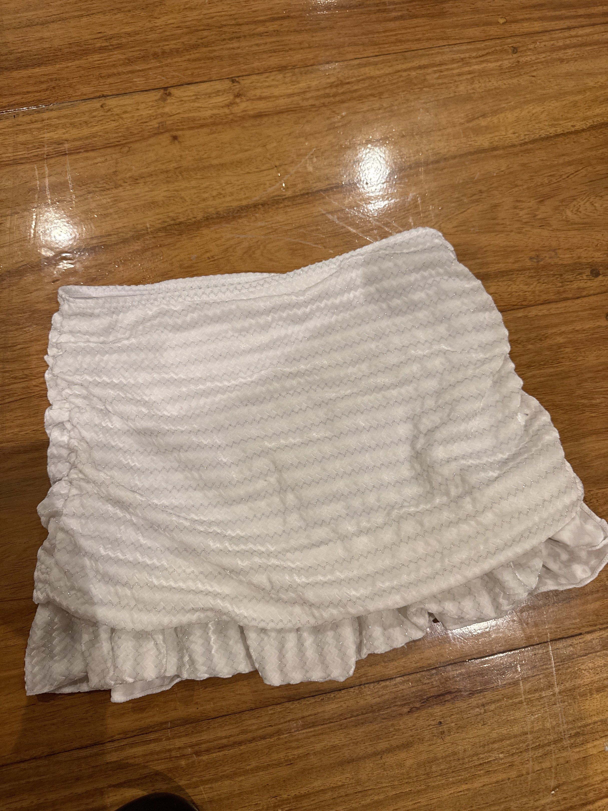 White Ruffled Mini Skirt (Category: Skirts) located in Manila. Submitted by eb.declutters (Listing ID 1417957309, Image 1). Description: - White mini skirt - Ruffled hem - Ruched design - Size S - Made in China - Material: 92% polyester, 8% spandex.