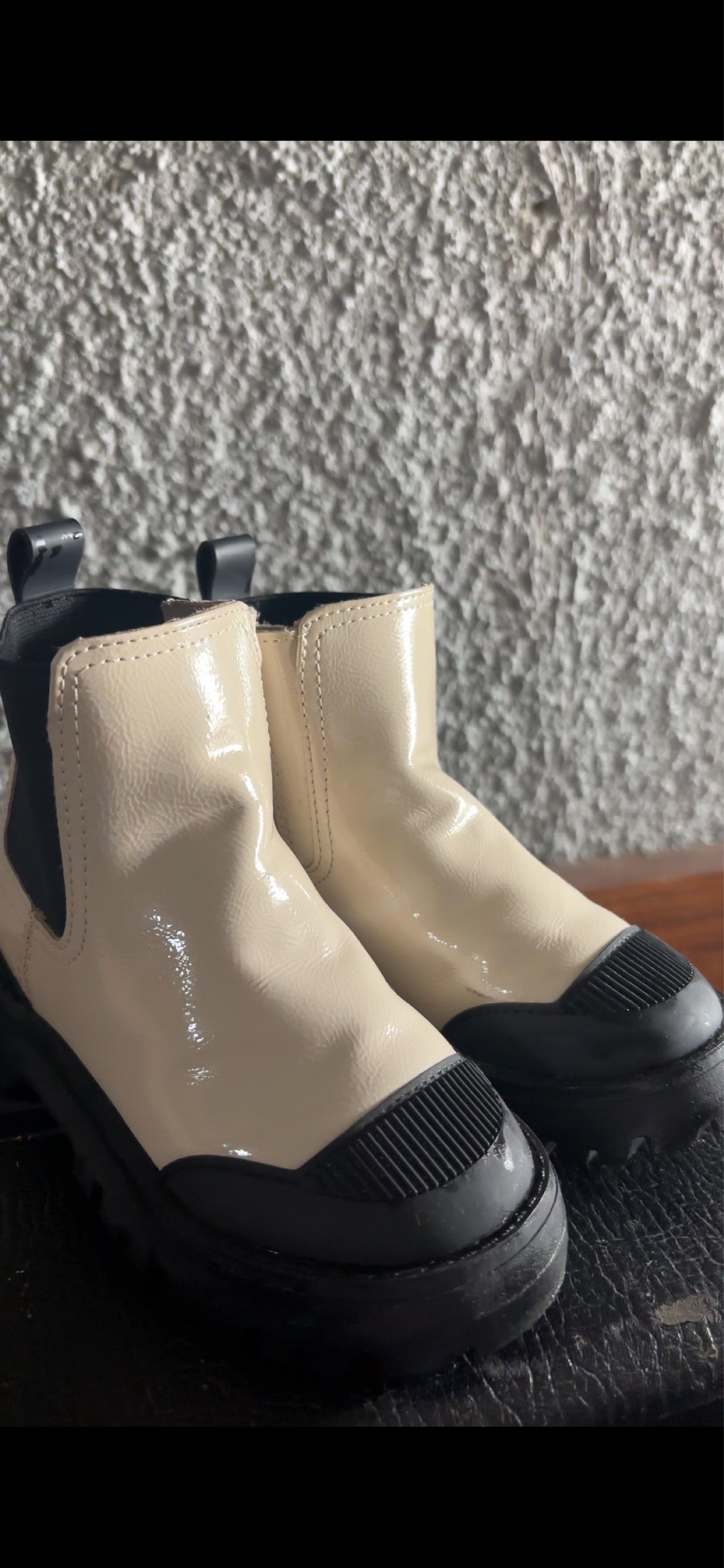 Zara Boots 14.9cm (Category: Babies & Kids Fashion) located in San Jose. Submitted by arakyer (Listing ID 1417823174, Image 1). Description: - Creamy white Chelsea boots with a glossy finish - Black elastic side panels - Textured black toe reinforcement - Durable black rubber sole - Convenient pull tab at the back - Versatile and stylish design.