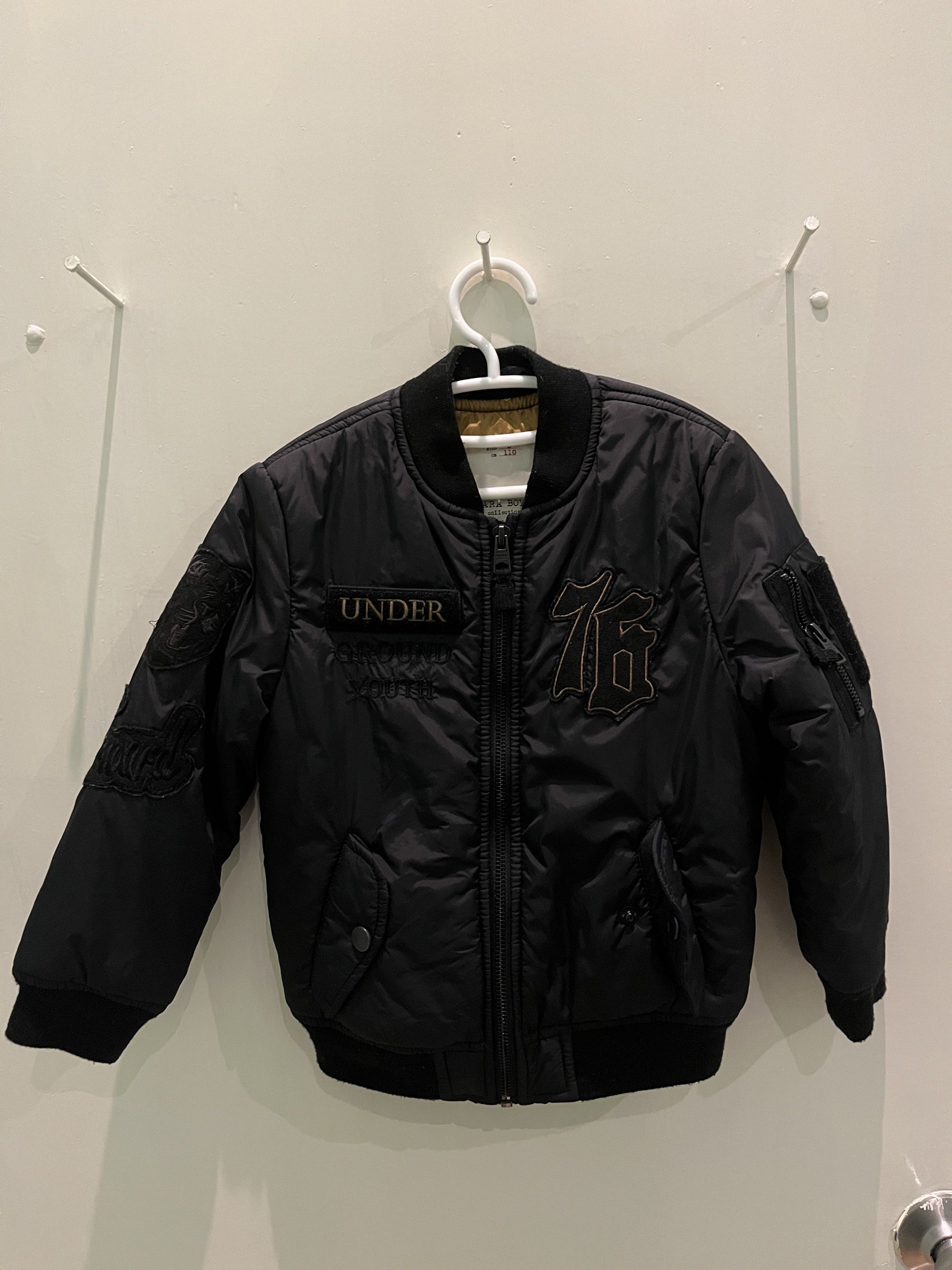 Zara Boys Bomber Jacket Size 5 (Category: Babies & Kids Fashion) located in Pasig City. Submitted by fmc828 (Listing ID 1417817096, Image 1). Description: - Zara Boys black bomber jacket - Size 5 (fits 110 cm) - Quilted design - Features "UNDER" and "76" patches - Two front pockets - Ribbed collar, cuffs, and hem - Made in Vietnam.