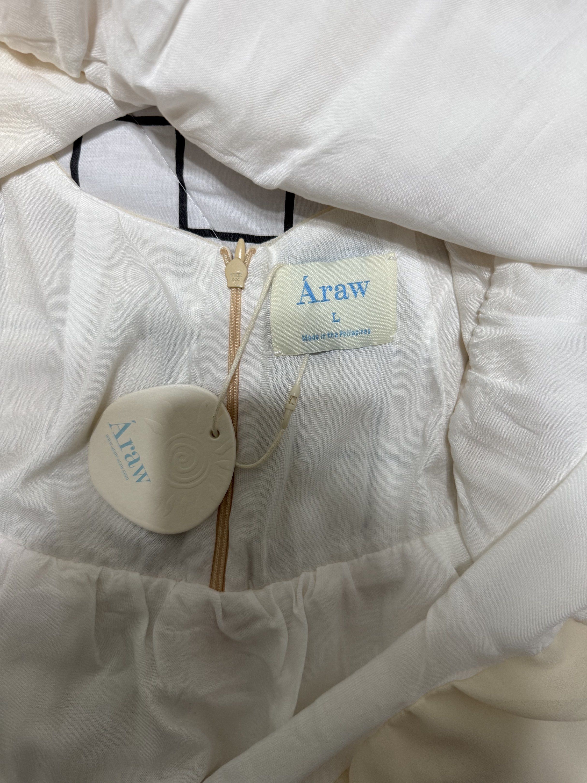 Araw The Line Bubble Dress (Category: Dresses) located in Makati City. Submitted by martina.declutters (Listing ID 1418107920, Image 3). Description: - Araw The Line white dress - Size: L - Sleeveless design - Round neckline - Flared hem - Back zipper closure - Made in the Philippines.