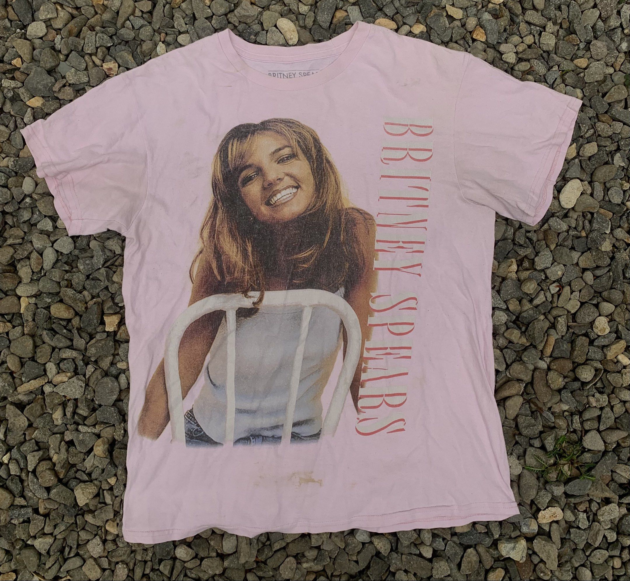 Britney Spears Pink Graphic Tee (Category: Shirts) located in Bacolod City. Submitted by lazythrifts (Listing ID 1418108655, Image 1). Description: - Pink Britney Spears t-shirt - Features a graphic of Britney Spears - "Britney Spears" text printed vertically - Short sleeves and crew neck - Visible stains on the front - Tag reads "Britney Spears".
