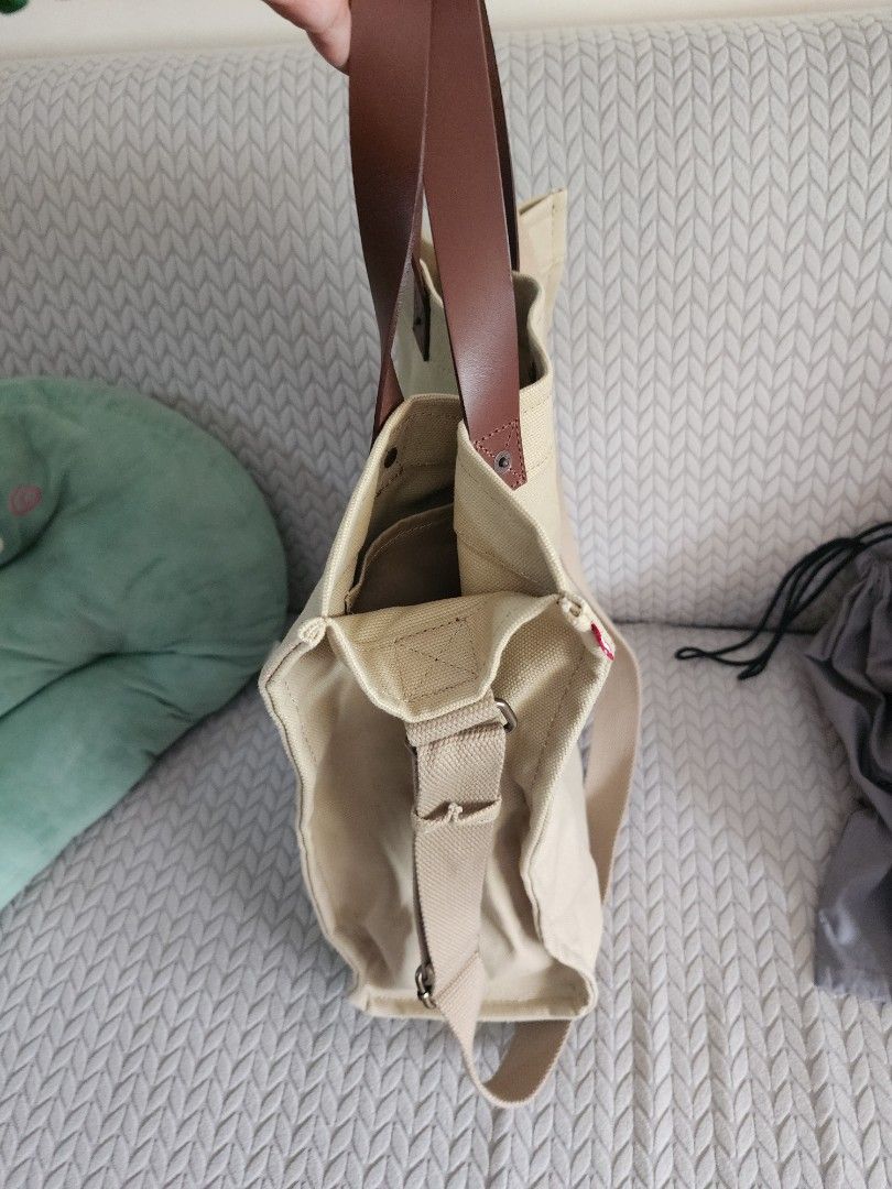 Canvas Tote Bag with Leather Handles (Category: Tote Bags) located in Quezon City. Submitted by deng43763 (Listing ID 1418053841, Image 3). Description: Tote bag features a canvas exterior with leather handles and a detachable shoulder strap. It has multiple compartments inside, including a zippered pocket. The bag is a neutral beige color..