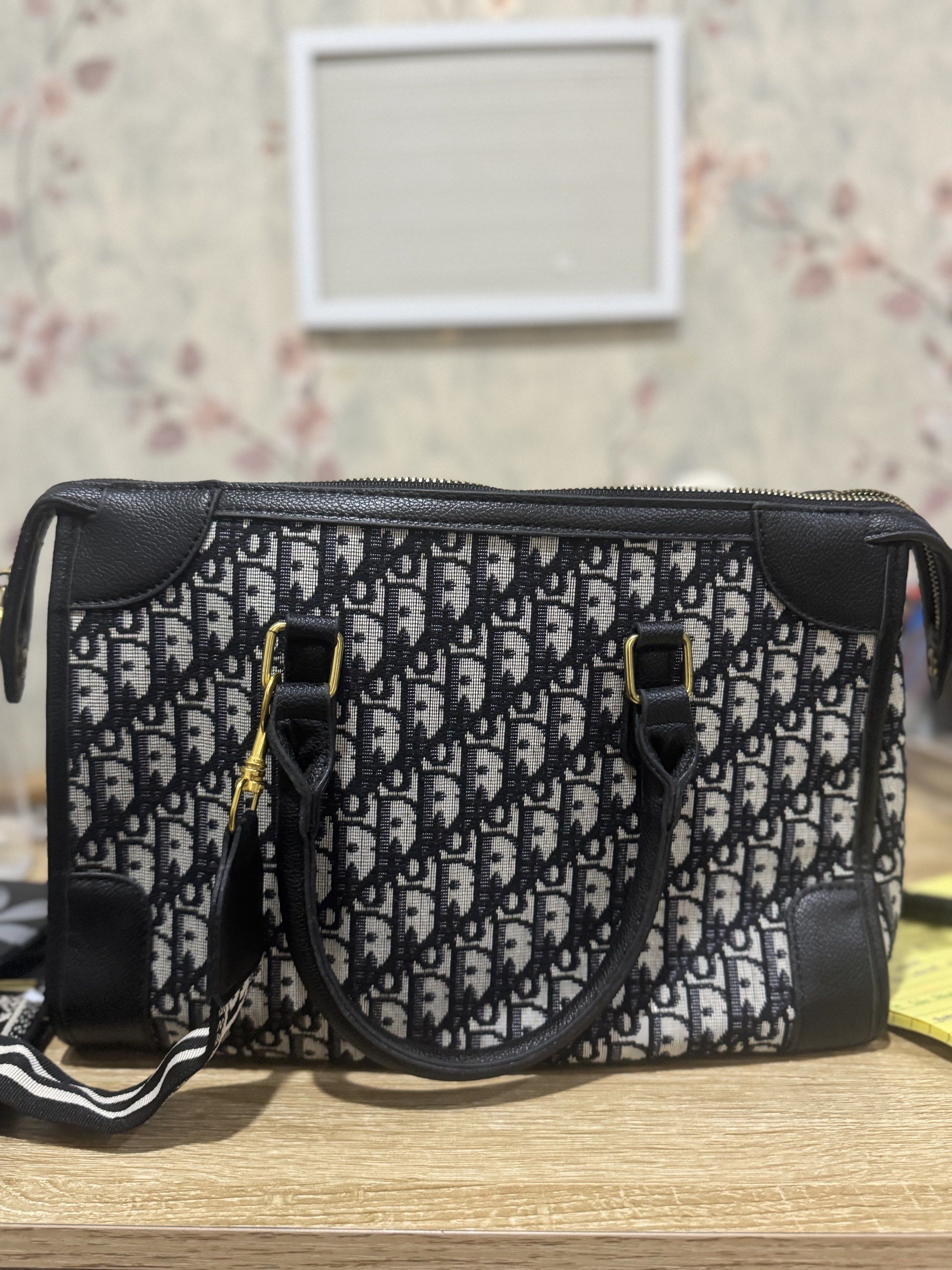 Christian Dior (Category: Luxury Bags & Wallets) located in Manila. Submitted by angeljuhan74050 (Listing ID 1418016368, Image 2). Description: - Authentic Dior Boston Bag - Iconic Oblique pattern - Top zip closure - Dual top handles - Detachable shoulder strap - Brown fabric lining - Interior slip pocket - Gold-tone hardware - Leather accents - Dior logo detail.