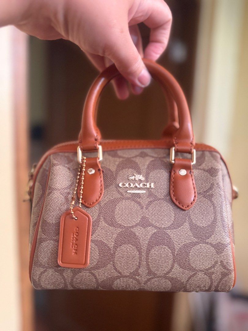 Coach Mini Brown Handbag with adjustable strap (Category: Luxury Bags & Wallets) located in Paranaque City. Submitted by lyn0618 (Listing ID 1418120606, Image 2). Description: FOR SALE! COACH MINI BROWN HANDBAG with adjustable strap NO ISSUES GOOD AS NEW.NOT USED COACH OUTLET STORE PURCHASED CLEAN AND WITH BLACK COACH TAG INTACT see picture . 1 OPEN POCKET INSIDE 1 Zippered Pocket INSIDE GOLD TONED HARDWARE CAN FIT IPHONE 16 or 17 pro max. Some e