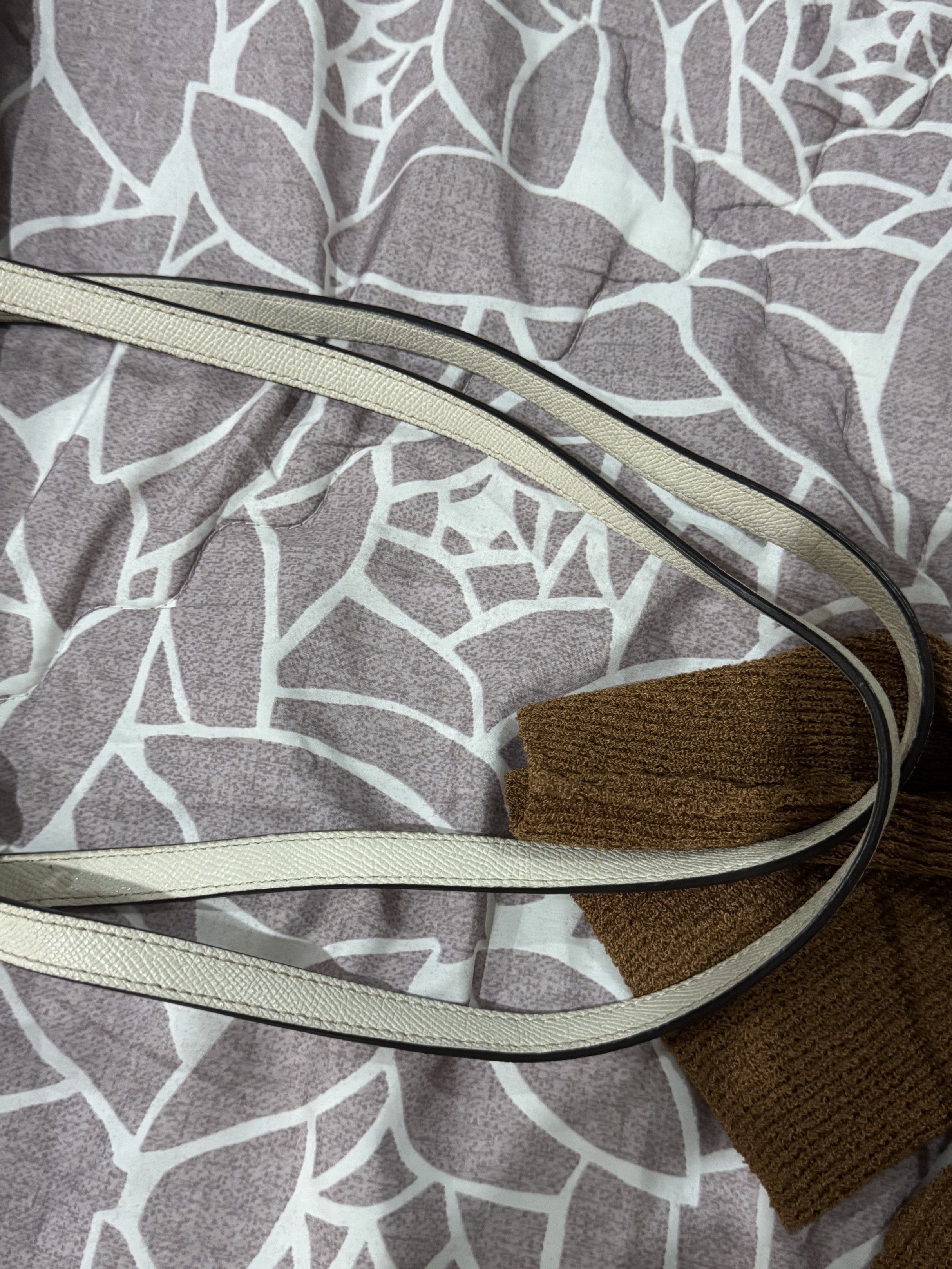 Coach Tote Bag (Category: Luxury Bags & Wallets) located in Sual. Submitted by Twinkle (Listing ID 1418155849, Image 3). Description: - Cream-colored Coach tote bag - Zip closure - Dual top handles - Includes Coach hang tag - Interior: zippered pocket and slip pocket - Gold-tone hardware - Coach logo on front - Dark interior lining - with signs of usages and discoloration that's not obvious.