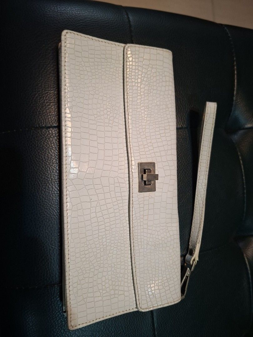 Fino Leatherware Clutch Bag (Category: Luxury Bags & Wallets) located in Quezon City. Submitted by apple.ana888 (Listing ID 1418075634, Image 1). Description: - Fino Leatherware clutch bag - Textured, off-white exterior - Secure clasp closure - Detachable wrist strap - Rectangular shape - Subtle embossed pattern - Interior: lighter shade (tan) - Ideal for special occasions or everyday use.