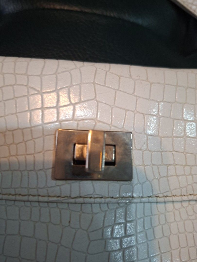 Fino Leatherware Clutch Bag (Category: Luxury Bags & Wallets) located in Quezon City. Submitted by apple.ana888 (Listing ID 1418075634, Image 2). Description: - Fino Leatherware clutch bag - Textured, off-white exterior - Secure clasp closure - Detachable wrist strap - Rectangular shape - Subtle embossed pattern - Interior: lighter shade (tan) - Ideal for special occasions or everyday use.
