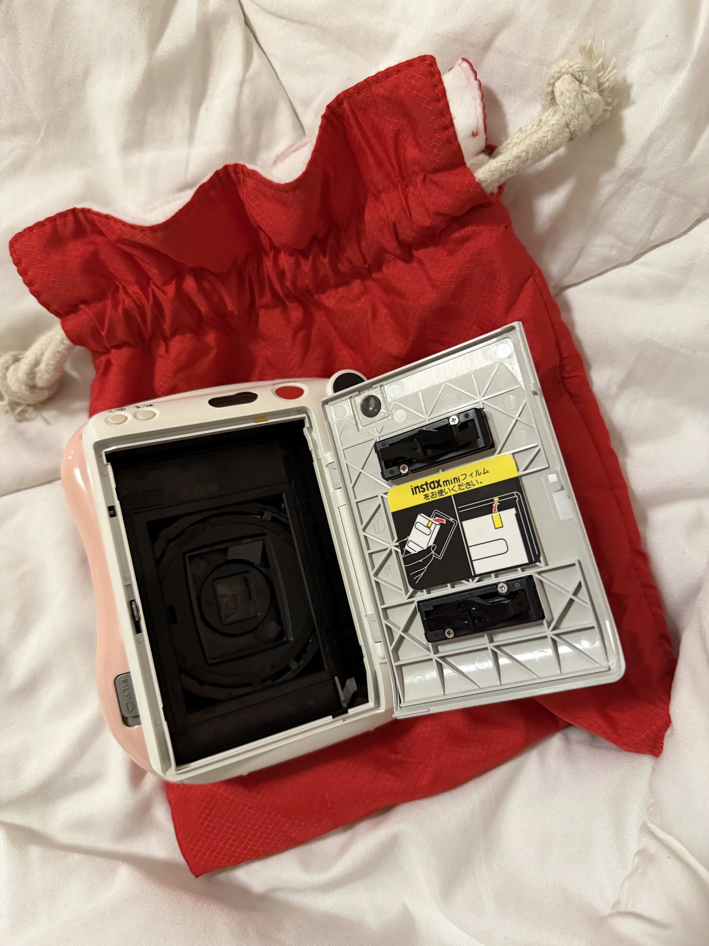 Fujifilm Instax Mini 25 (Category: Cameras) located in Caloocan City. Submitted by mdowmya (Listing ID 1418037668, Image 3). Description: - Fujifilm Instax Mini instant camera - Color: White and Pink - Lens: 60mm focus range - Includes a red carrying bag - Bag closure: Drawstring - Uses CR2 batteries Issues: batteries need to be changed .