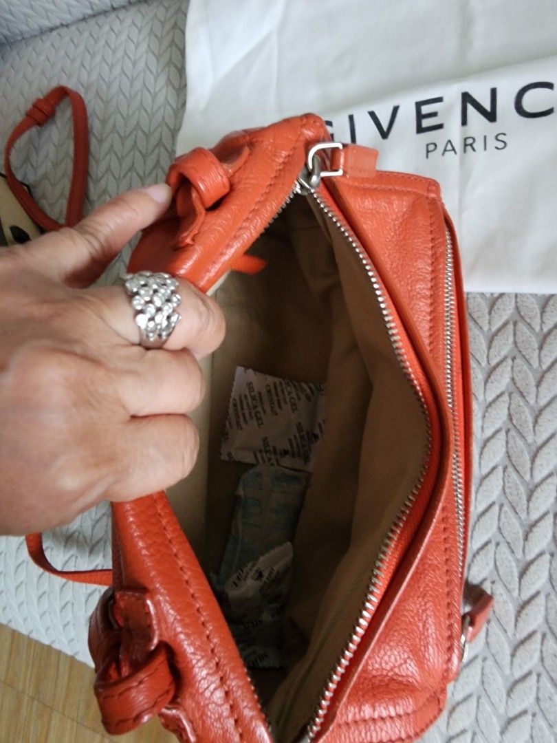 Givenchy Pandora Orange Leather Bag (Category: Luxury Bags & Wallets) located in Quezon City. Submitted by deng43763 (Listing ID 1418043335, Image 3). Description: - Authentic Givenchy Pandora bag - Vibrant orange color - Includes dust bag and card - Top handle and crossbody strap - Silver-tone hardware - Zip closure - Givenchy logo visible.