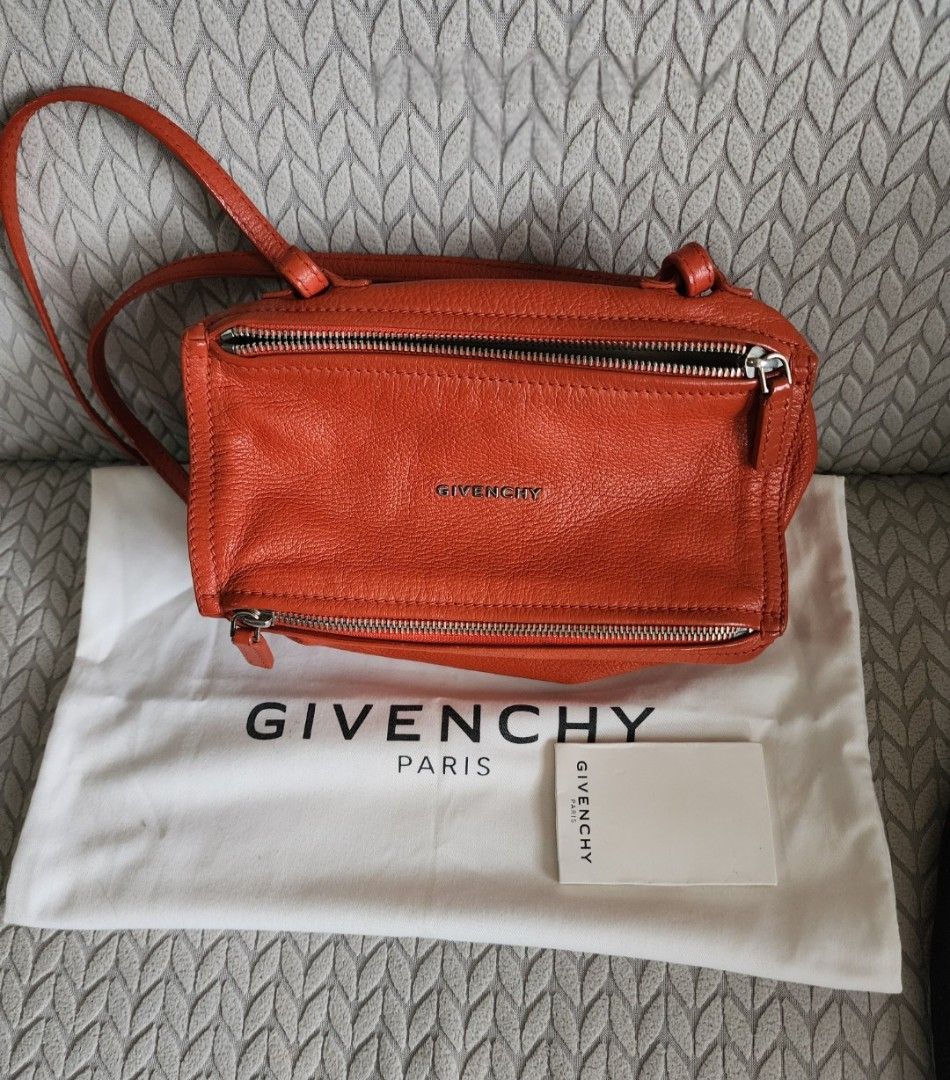 Givenchy Pandora Orange Leather Bag (Category: Luxury Bags & Wallets) located in Quezon City. Submitted by deng43763 (Listing ID 1418043335, Image 1). Description: - Authentic Givenchy Pandora bag - Vibrant orange color - Includes dust bag and card - Top handle and crossbody strap - Silver-tone hardware - Zip closure - Givenchy logo visible.