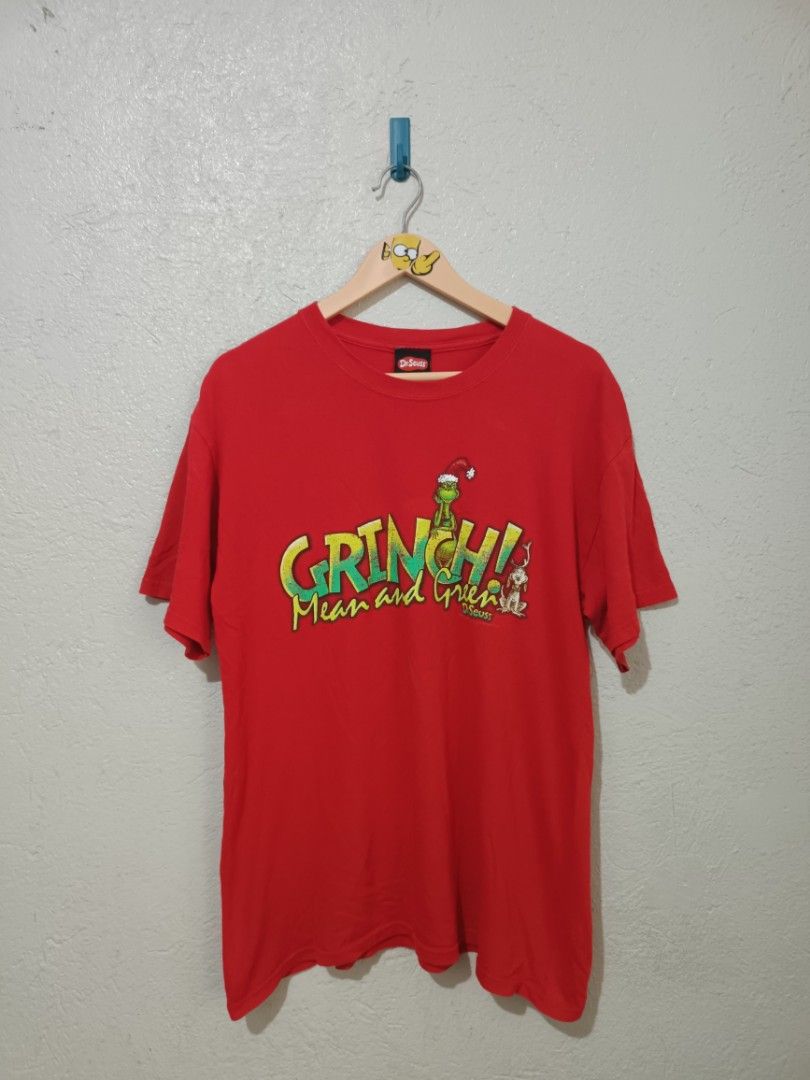 Grinch Christmas T-shirts (Category: Tshirts & Polo Shirts ) located in Dumaguete. Submitted by pimenteltrixian11 (Listing ID 1418098981, Image 2). Description: Two Grinch-themed t-shirts are available. One is dark gray with "Merry Grinchmas" print, and the other is red with "Grinch! Mean and Green" print. The red shirt is a Gildan Heavy Cotton shirt. Both shirts feature the Grinch character. The red shirt is from 2001, Dr. Seuss Enterprises, L.P