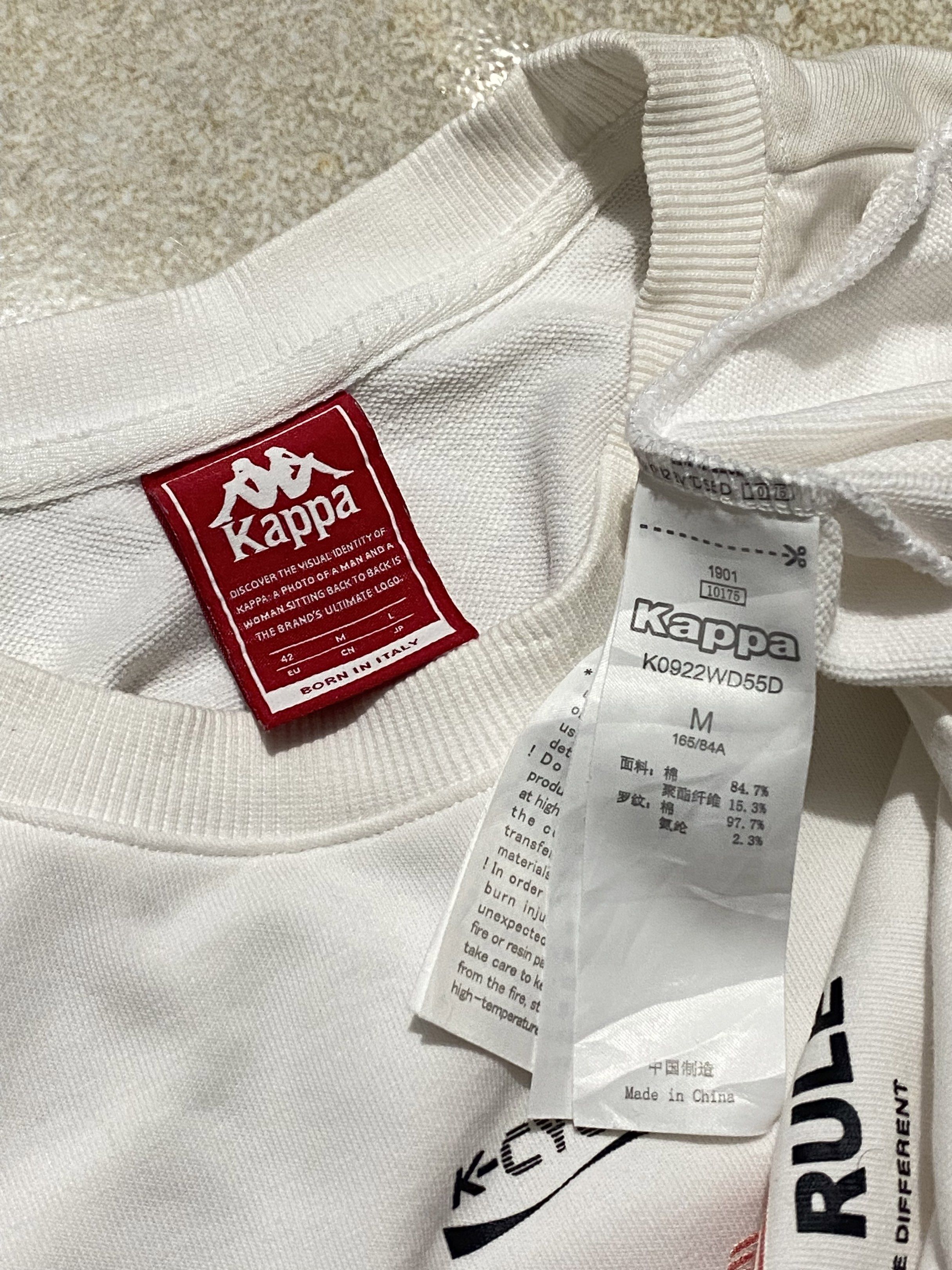 Kappa K-Cycle White T-shirt (Category: Shirts) located in Pasay City. Submitted by thriftiest.ph (Listing ID 1418189739, Image 2). Description: Dimes: 19x20 Color Rate: 9.5/10 Isuue: Washable Yellow Stain/Needs Wash White Kappa K-Cycle T-shirt. Features the Kappa logo on the sleeve and a graphic on the front. The shirt has a crew neck and short sleeves. The size is M/165/84A. Made in China. The tag indicates the shirt was born in Italy..
