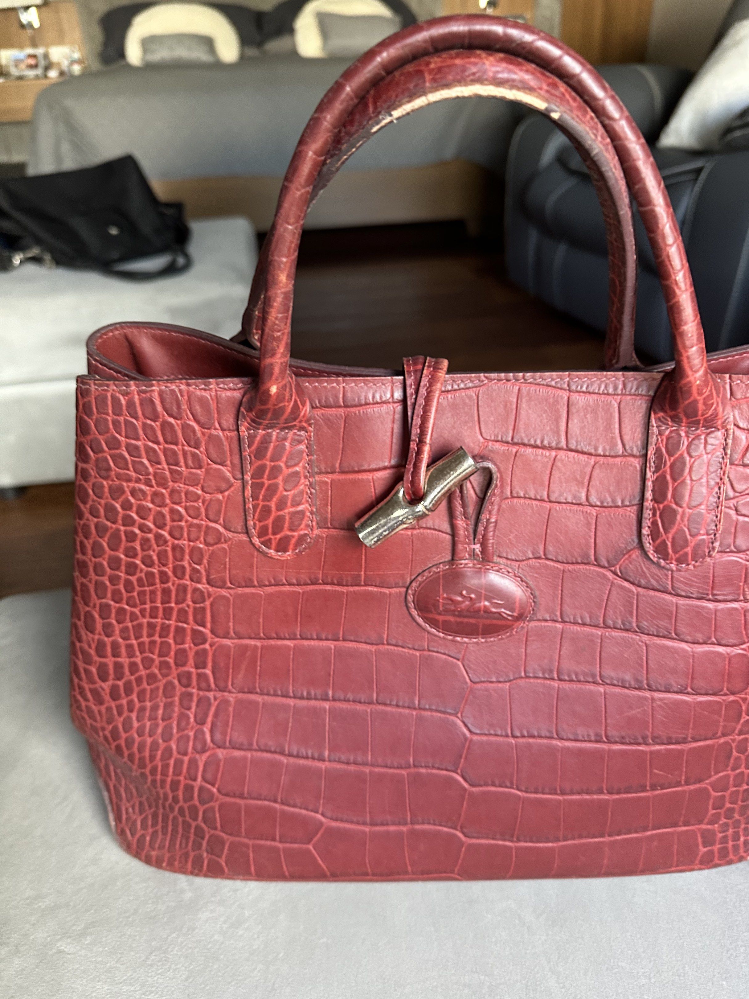 Longchamp Croc-Embossed Leather Handbag (Category: Luxury Bags & Wallets) located in Marikina City. Submitted by am.psalms (Listing ID 1418099350, Image 3). Description: - Original - Longchamp handbag in burgundy - Croc-embossed leather exterior - Features top handles and clasp closure - Spacious interior for essentials - Includes Longchamp logo charm - Perfect for everyday use.