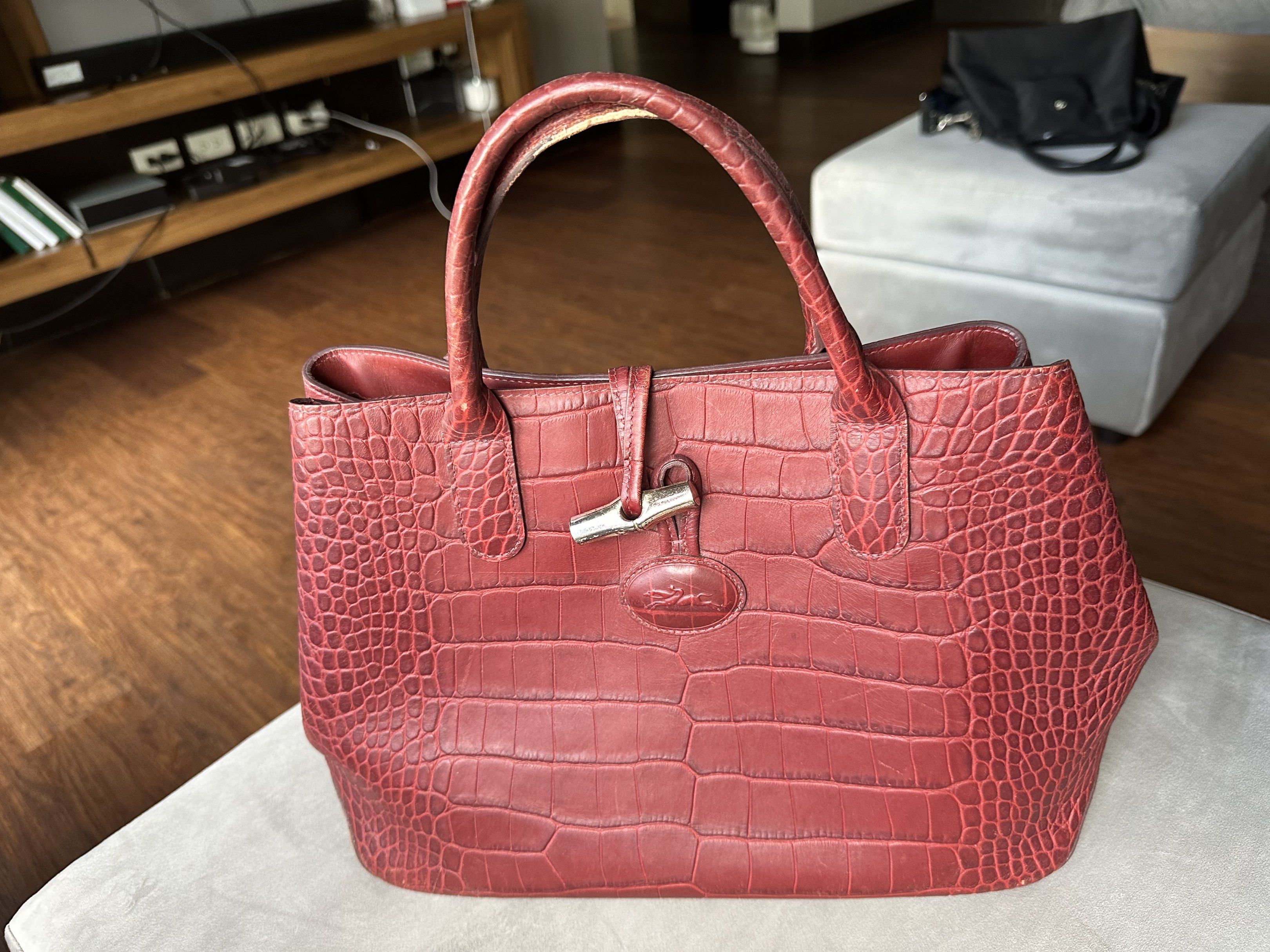 Longchamp Croc-Embossed Leather Handbag (Category: Luxury Bags & Wallets) located in Marikina City. Submitted by am.psalms (Listing ID 1418099350, Image 1). Description: - Original - Longchamp handbag in burgundy - Croc-embossed leather exterior - Features top handles and clasp closure - Spacious interior for essentials - Includes Longchamp logo charm - Perfect for everyday use.