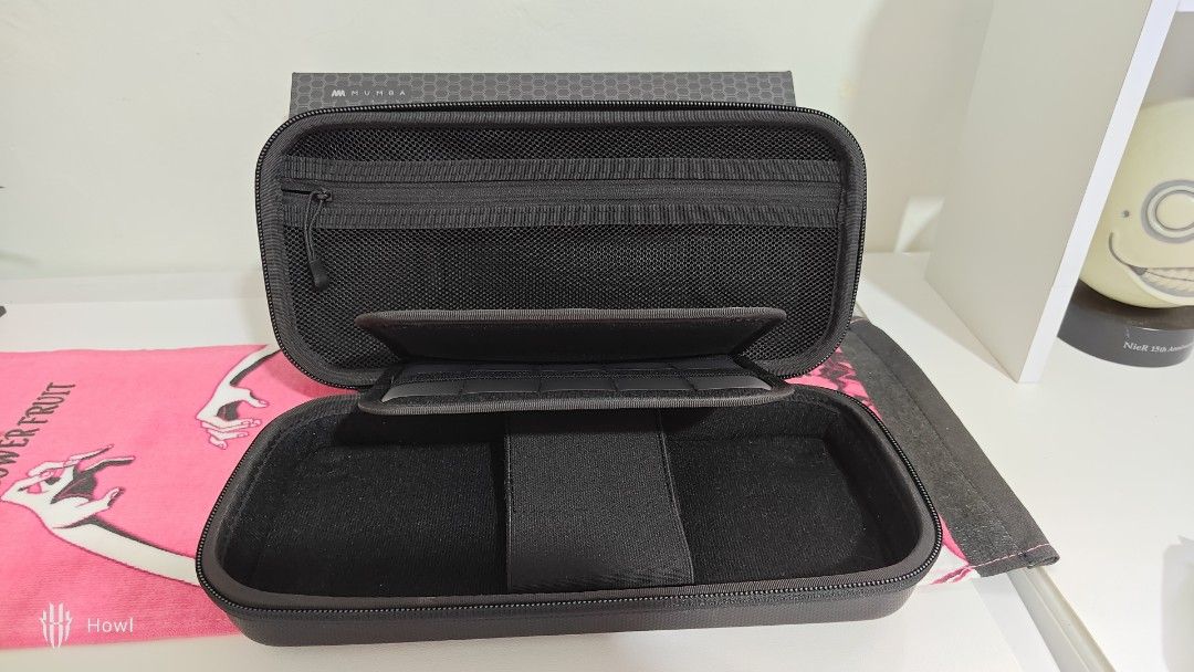 [NO ISSUE] Mumba Plus Protective Hard Shell Travel Carrying Case (Category: Cases & Sleeves) located in Antipolo. Submitted by behowling (Listing ID 1418018572, Image 2). Description: Newly bought, fits mobapad, complete and NO DAMAGE RFS: Wanted a slimmer storage - Protective hard shell case for Nintendo Switch Oled - Features a zippered compartment for accessories - Separate compartment for the console - Black with textured exterior.
