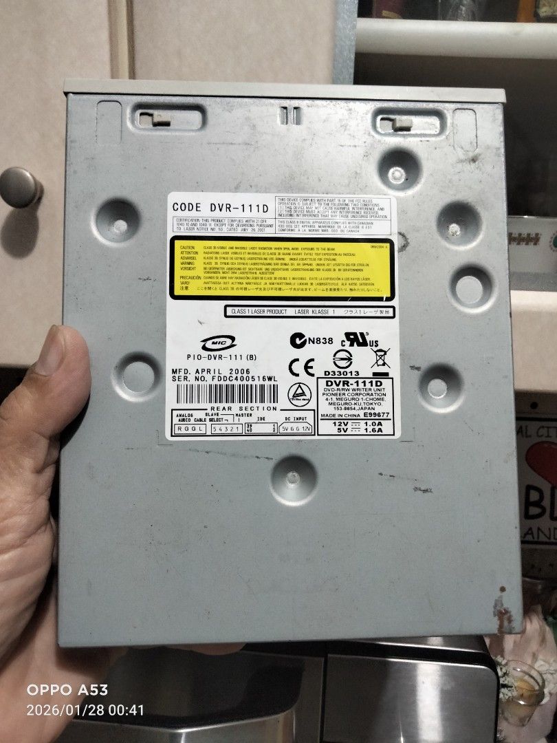 Samsung DVR-111D DVD-RW Drive (Category: Hard Disks & Thumbdrives) located in Carmona. Submitted by rpute (Listing ID 1418188224, Image 2). Description: Samsung DVR-111D DVD-RW drive. It has a tray-loading mechanism and supports DVD and CD formats. The drive has a silver/beige front panel with a disc eject button and an LED indicator. The rear section shows the model number and other specifications. It is a standard 5.25-inch drive..