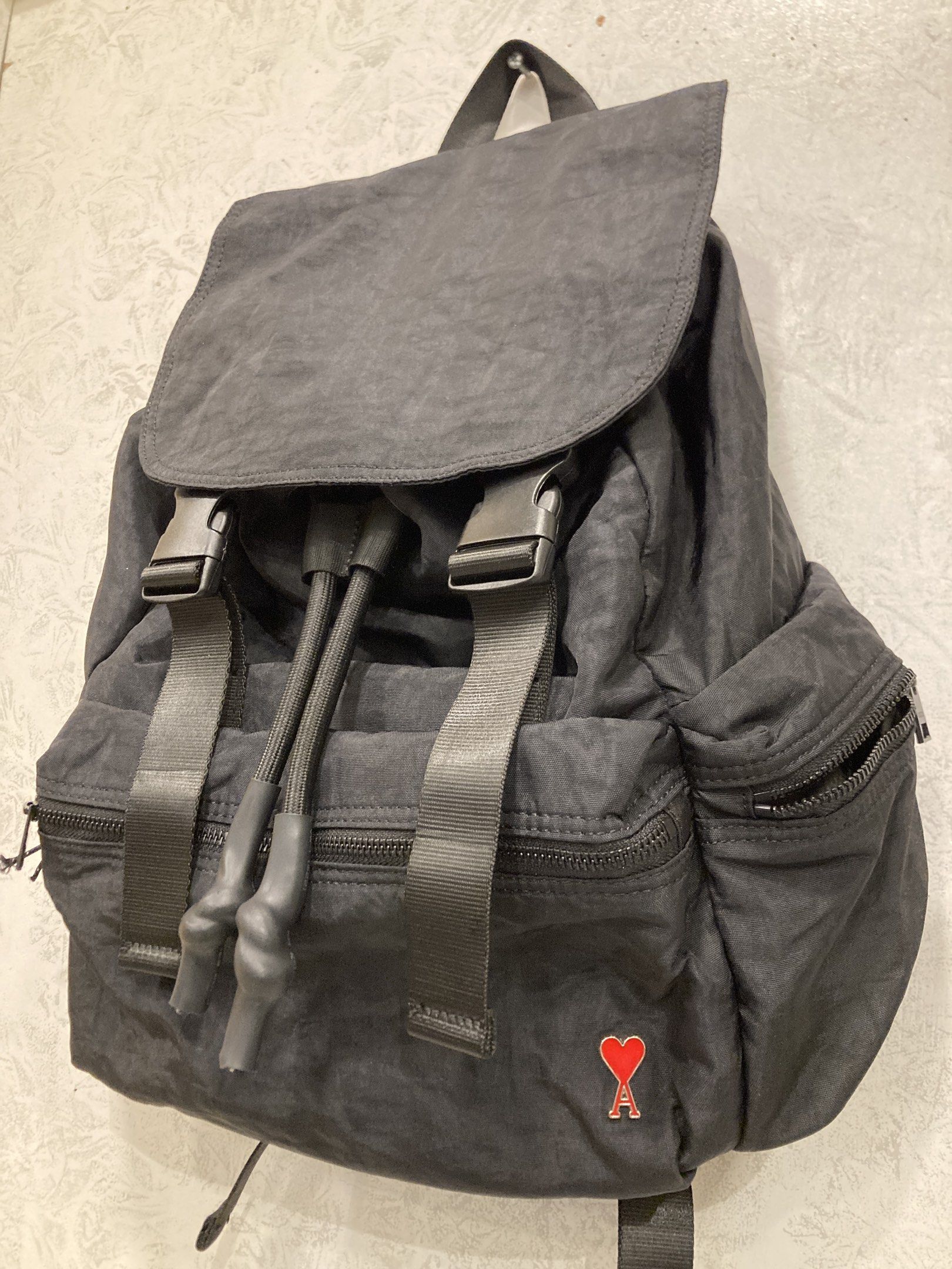 AMI Alexandre Mattiussi Backpack (Category: Luxury Bags & Wallets) located in Quezon City. Submitted by janisu0303 (Listing ID 1418393543, Image 2). Description: - Black AMI Alexandre Mattiussi backpack - Flap closure with buckle straps - Front zip pocket - Side pockets - AMI logo on front - Top handle - Adjustable shoulder straps - Mesh lining inside - Brand label inside 7500 php Good Condition Fairview Area meetups Or shipping .