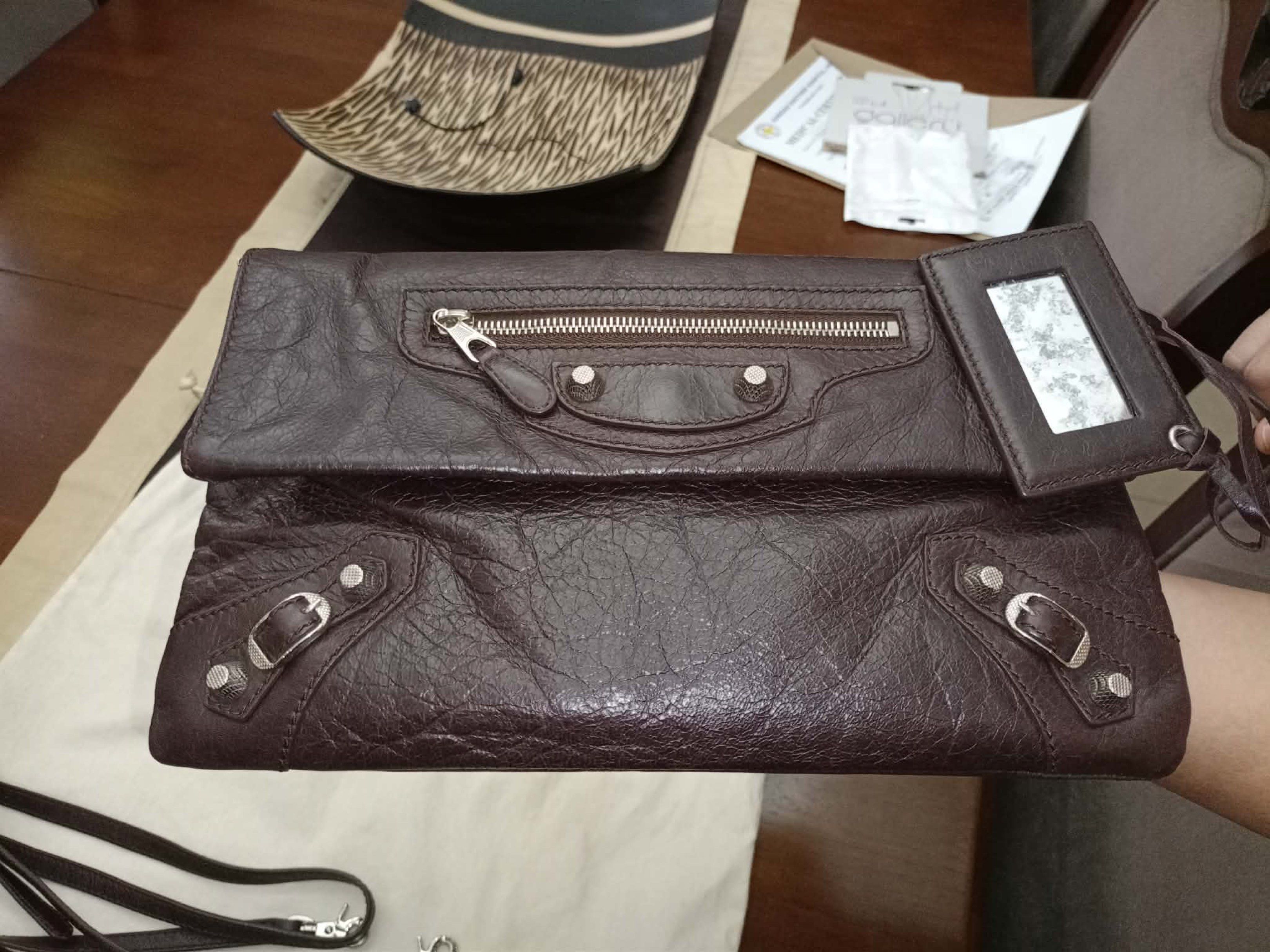 Balenciaga Envelope Clutch (Category: Luxury Bags & Wallets) located in Surigao. Submitted by kools_corner22 (Listing ID 1418253645, Image 3). Description: - Balenciaga Envelope Clutch - Chocolate Brown leather - Detachable shoulder strap - Includes a small mirror - Zip Top - Interior zip pocket - Silver hardware - Comes with dust bag and cards.