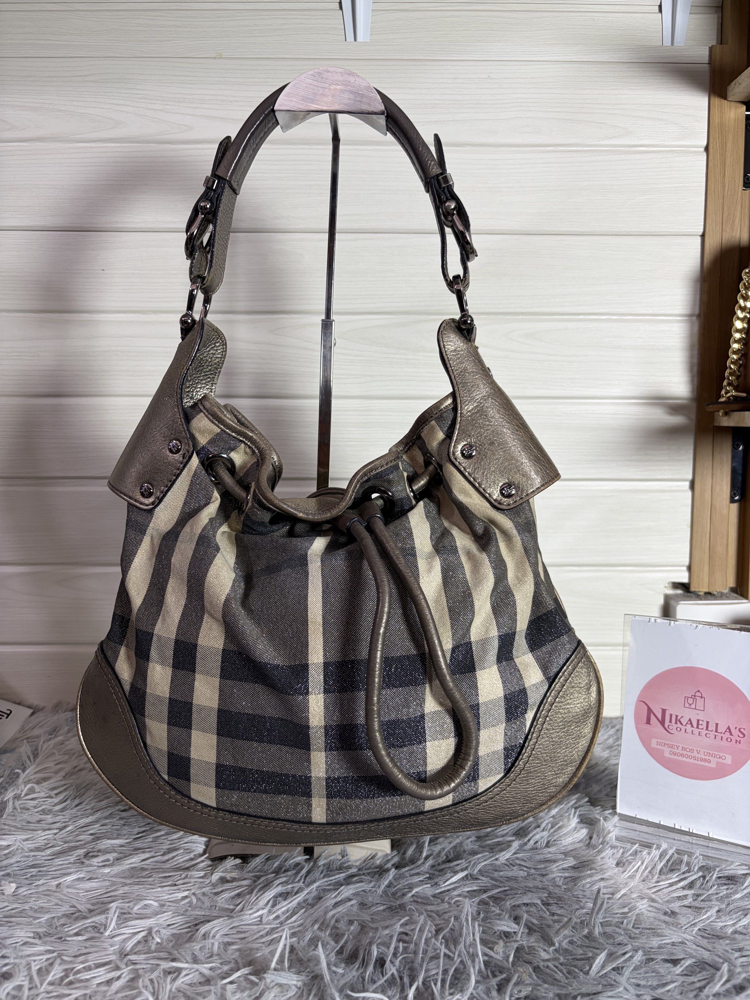 Burberry Hobo Bag (Category: Luxury Bags & Wallets) located in Malvar. Submitted by nikaellascollection_0923 (Listing ID 1418249407, Image 1). Description: - Authentic Burberry hobo bag - Classic check pattern - Drawstring closure - Metallic leather trim - Interior zippered pocket - Comfortable shoulder strap - Stylish design - Perfect for everyday use.