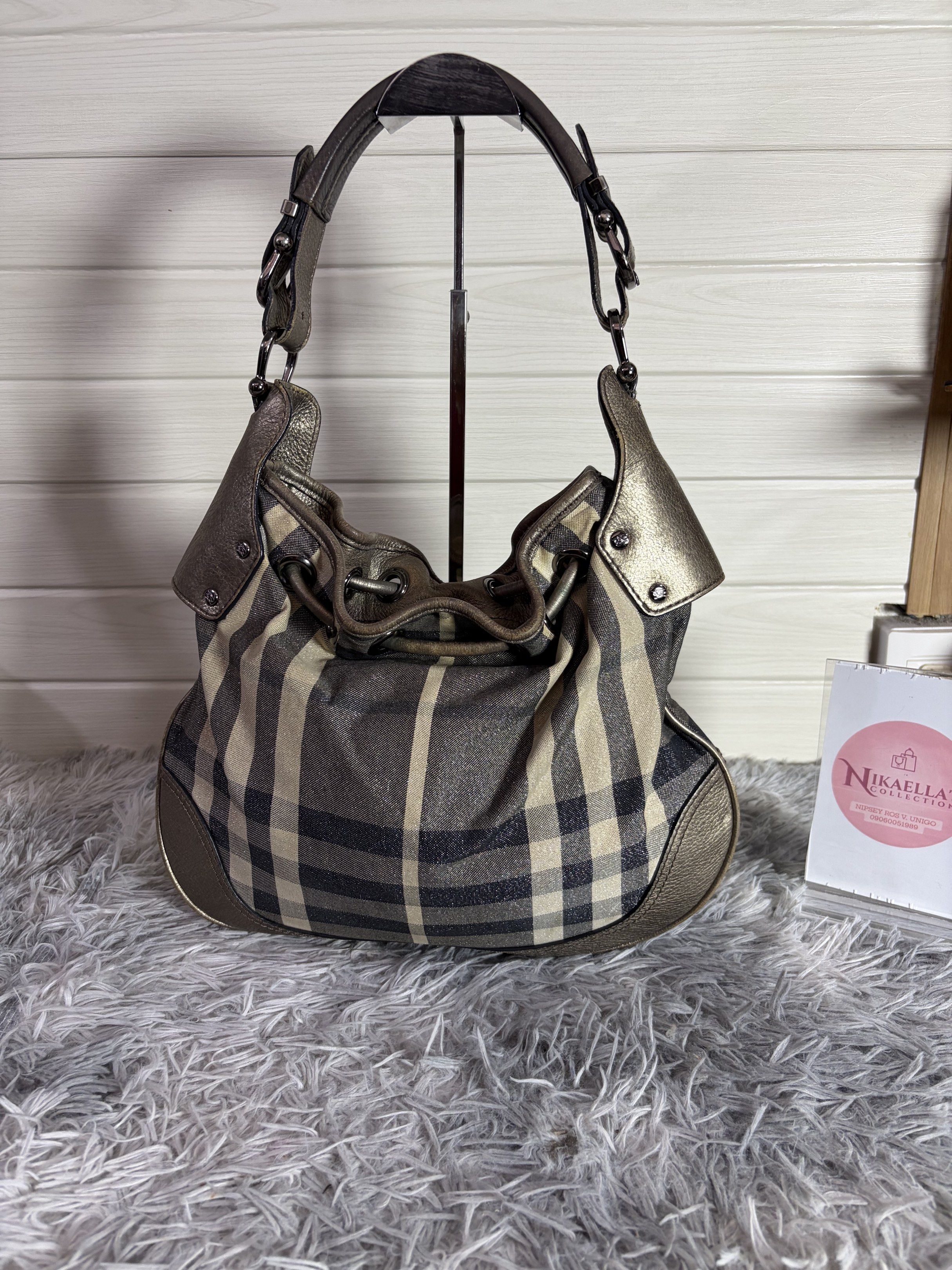 Burberry Hobo Bag (Category: Luxury Bags & Wallets) located in Malvar. Submitted by nikaellascollection_0923 (Listing ID 1418249407, Image 2). Description: - Authentic Burberry hobo bag - Classic check pattern - Drawstring closure - Metallic leather trim - Interior zippered pocket - Comfortable shoulder strap - Stylish design - Perfect for everyday use.