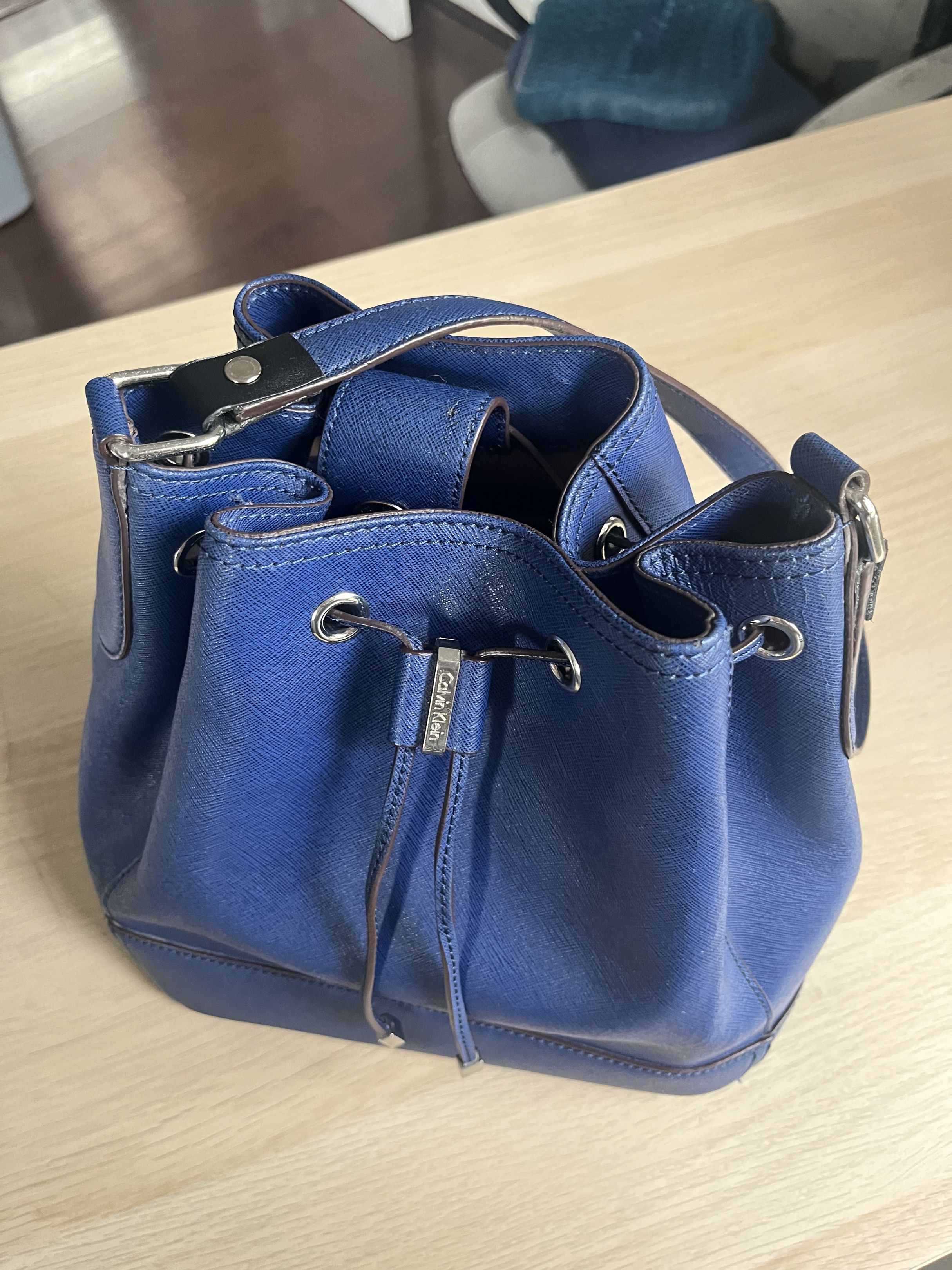 Calvin Klein Bucket Bag - Navy Blue (Category: Luxury Bags & Wallets) located in Manila. Submitted by alexashops (Listing ID 1418268401, Image 2). Description: - Calvin Klein bucket bag - Navy blue color - Bought in US - Drawstring closure - Shoulder strap - Silver-tone hardware - Calvin Klein logo on front - Textured material - Structured shape - Flat base.