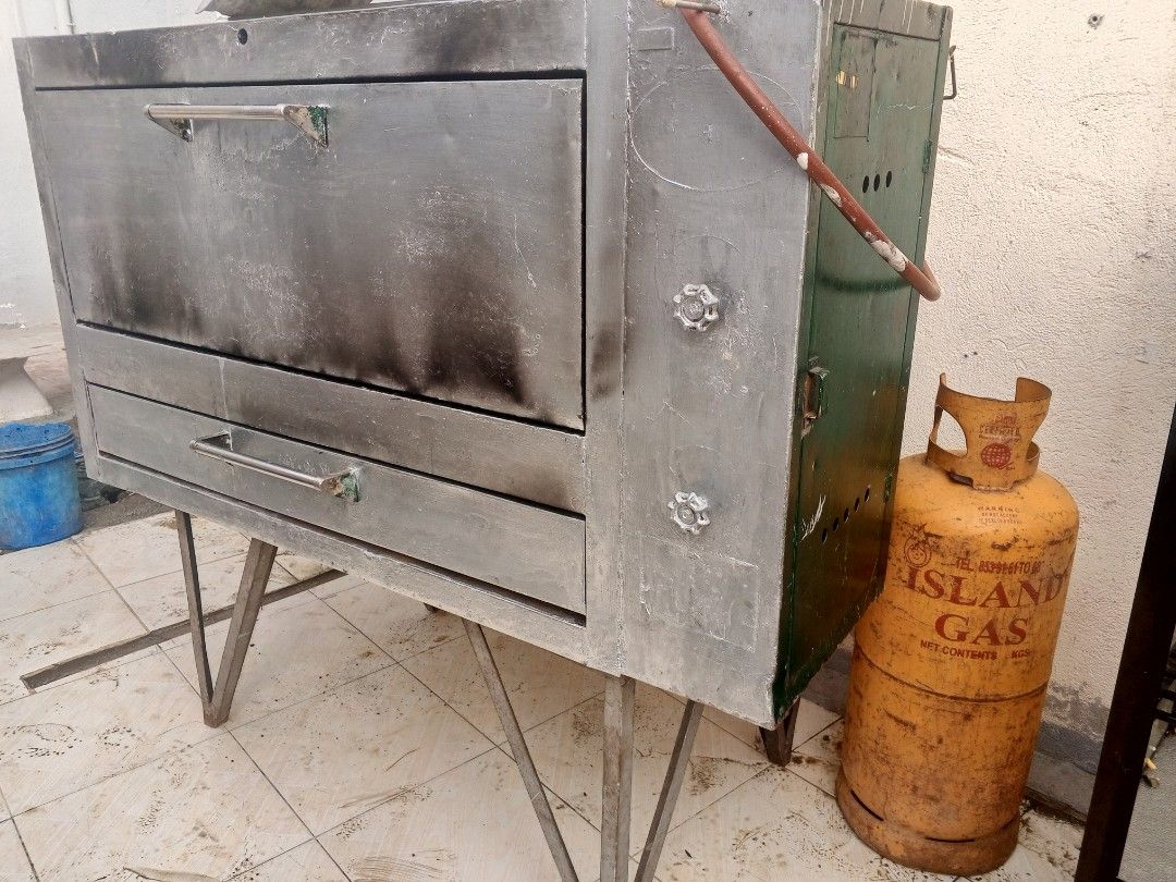 12 TRAYS Commercial Oven and Display Case (Category: Ovens & Toasters) located in Rodriguez. Submitted by amara0914 (Listing ID 1418211058, Image 1). Description: - Commercial oven with gas connection and Island Gas tank. - Stainless steel exterior. - Includes a glass display case with multiple shelves. - Display case has a black frame. - Ideal for small business use..