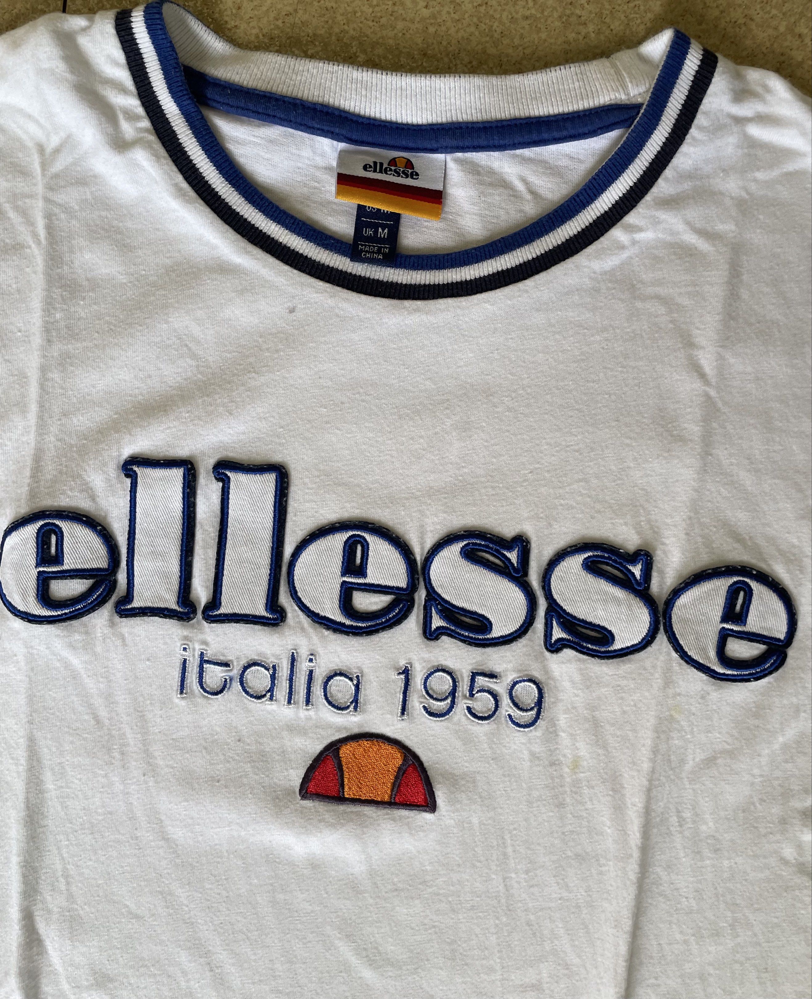 Ellesse Italia T-shirt (Category: Tshirts & Polo Shirts ) located in Manila. Submitted by wavy.scentss (Listing ID 1418281011, Image 2). Description: ✧ Very Good Condition ✔️ Gcash/Maya payment only (Cash for meet ups only) ✔️ PAY AS YOU ORDER or PAY BEFORE SHIPMENT 📍MANILA - QC - Ellesse T-shirt - Size: M - Color: White with blue accents - Features the "ellesse italia 1959" logo - Crew neck with blue and white stripes - Blue sleeves - Plain whi