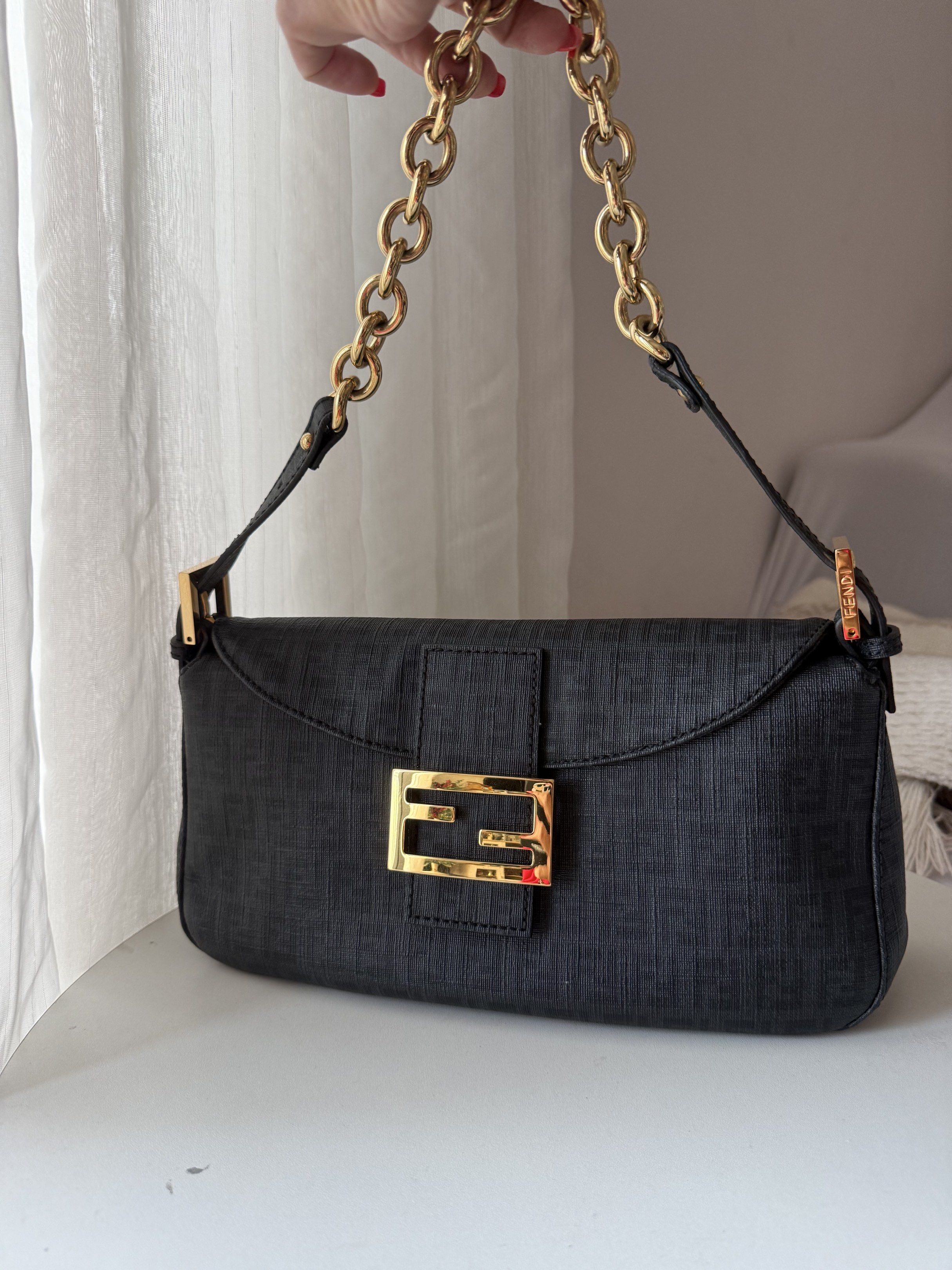 Fendi Baguette Bag with Gold Chain (Category: Luxury Bags & Wallets) located in Makati City. Submitted by vintage_beauty1 (Listing ID 1418212821, Image 1). Description: - Authentic classic Fendi Baguette bag Great condition Used only few times. Always keep stored properly in the dustbag. Clean interior and exterior -Very rare hard to find gold chain hardware - Color: Black - Gold chain strap - Gold-tone FF logo clasp and hardware - Red fabric int