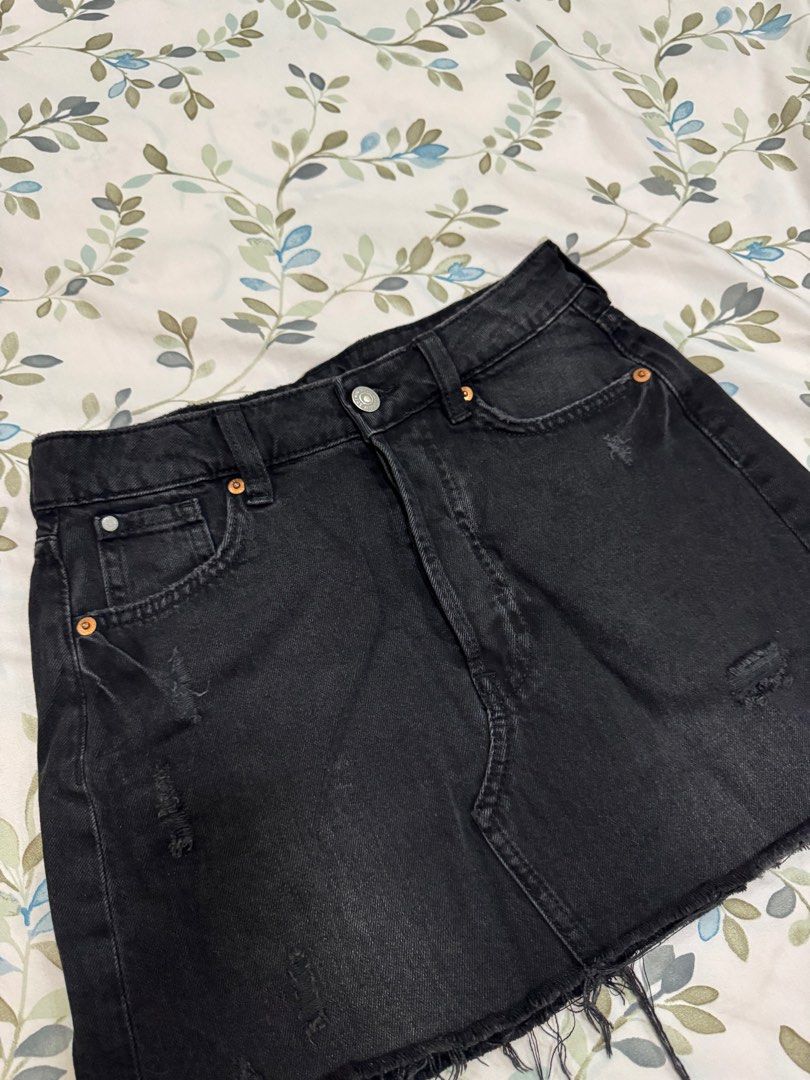 H&M Distressed Black Denim Mini Skirt (Category: Skirts) located in Antipolo. Submitted by nbrns (Listing ID 1418352790, Image 2). Description: - H&M black denim mini skirt - Features a raw hem and distressed details - Includes front and back pockets - Size 34 - Button and zipper closure.