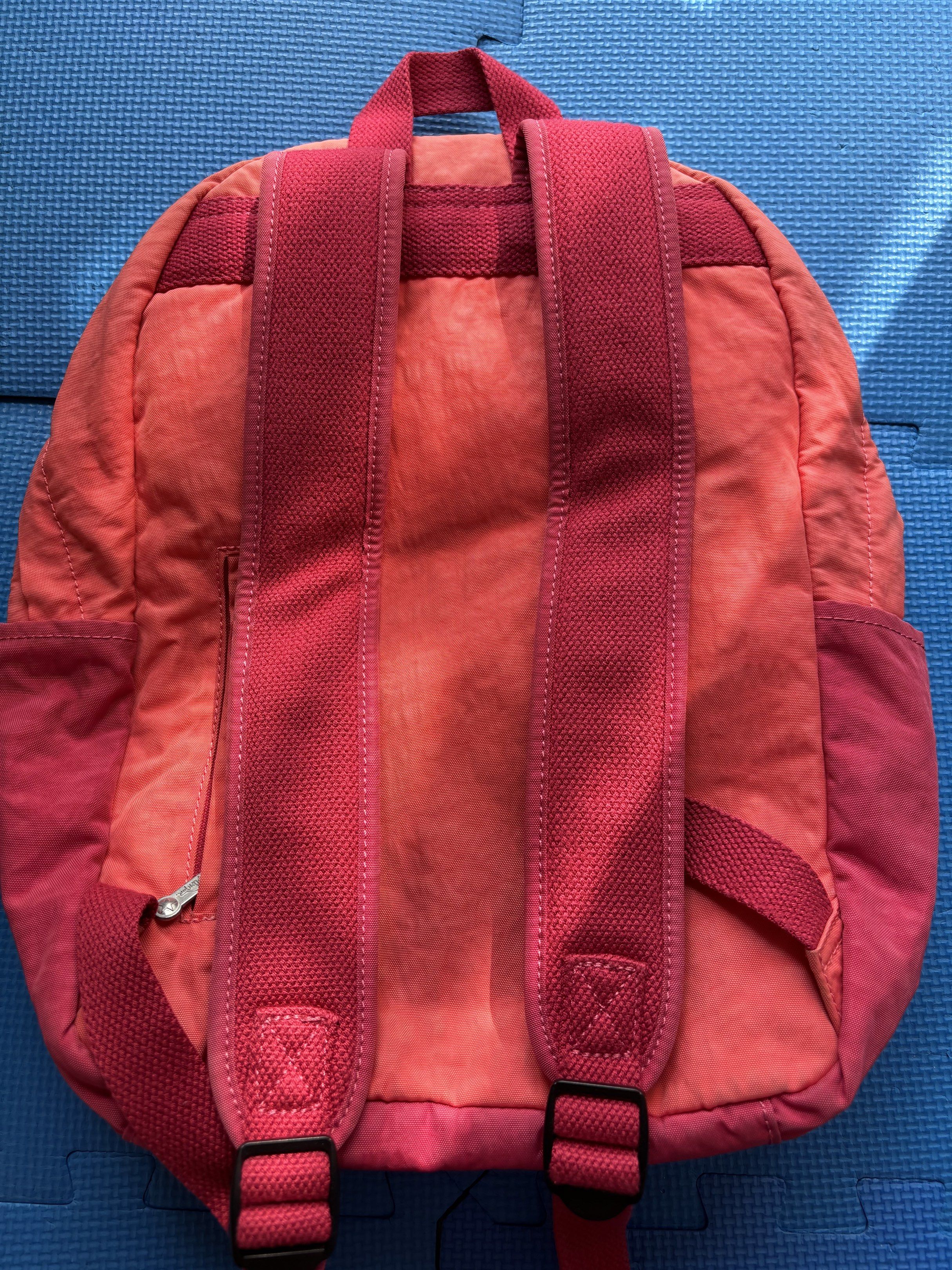 Kipling Backpack （分類：背囊）位於 Hong Kong。 由 carcaca 提交（商品編號 1418322258，圖片 2）。簡介： Kipling backpack features a vibrant pink and orange color scheme. It has a front pocket with the Kipling logo and comes with a small monkey keychain. The backpack has adjustable shoulder straps and a top handle. The back of the backpack has a zipper pocket.。