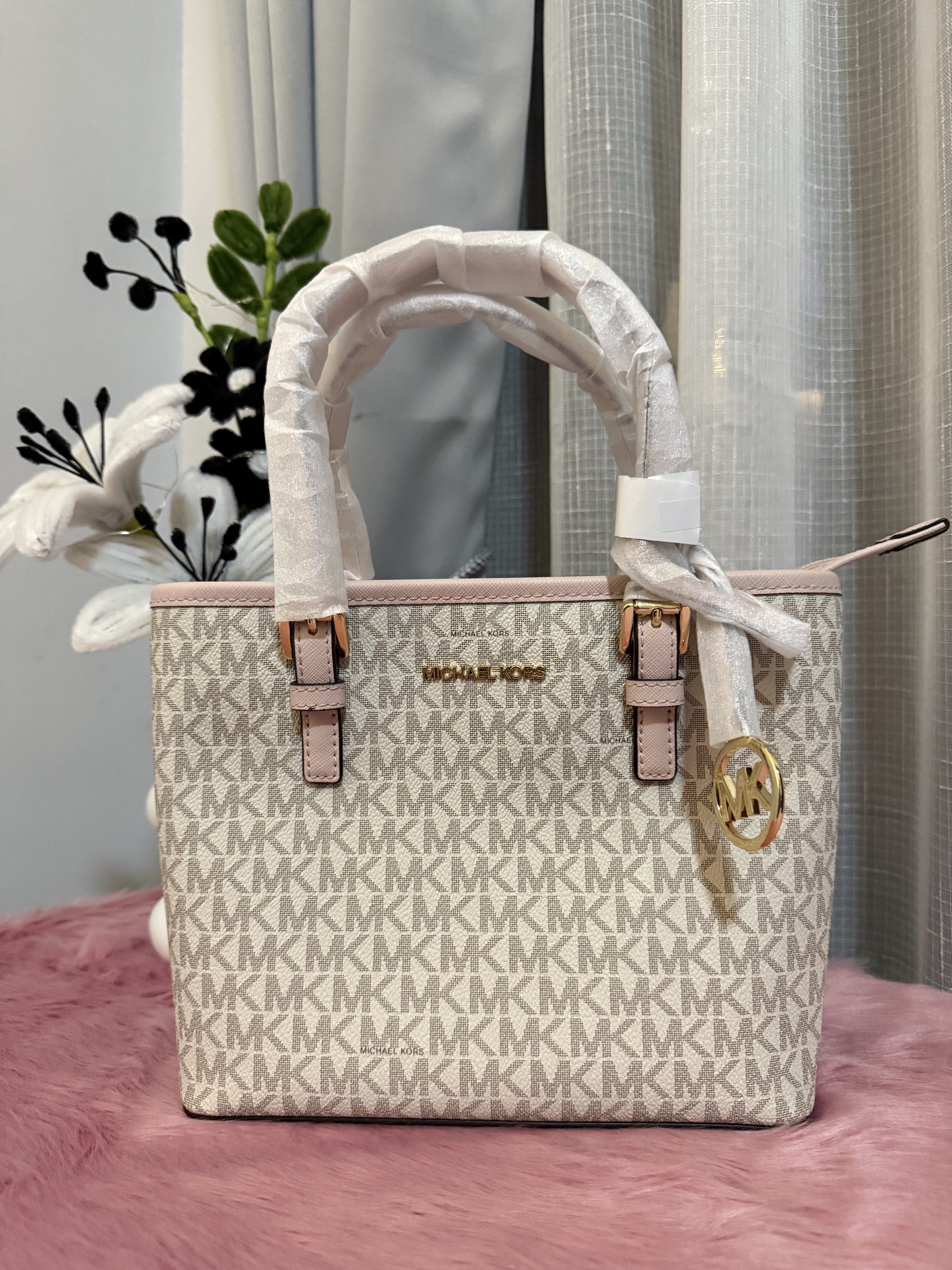 Michael Kors Tote Bag (Category: Luxury Bags & Wallets) located in Padre Garcia. Submitted by riailagan49560 (Listing ID 1418339359, Image 1). Description: - Michael Kors tote bag - Signature MK print - Pink trim and handles - Gold-tone logo charm - Top handle design - Main compartment - Small pocket - Stylish and versatile for everyday use.