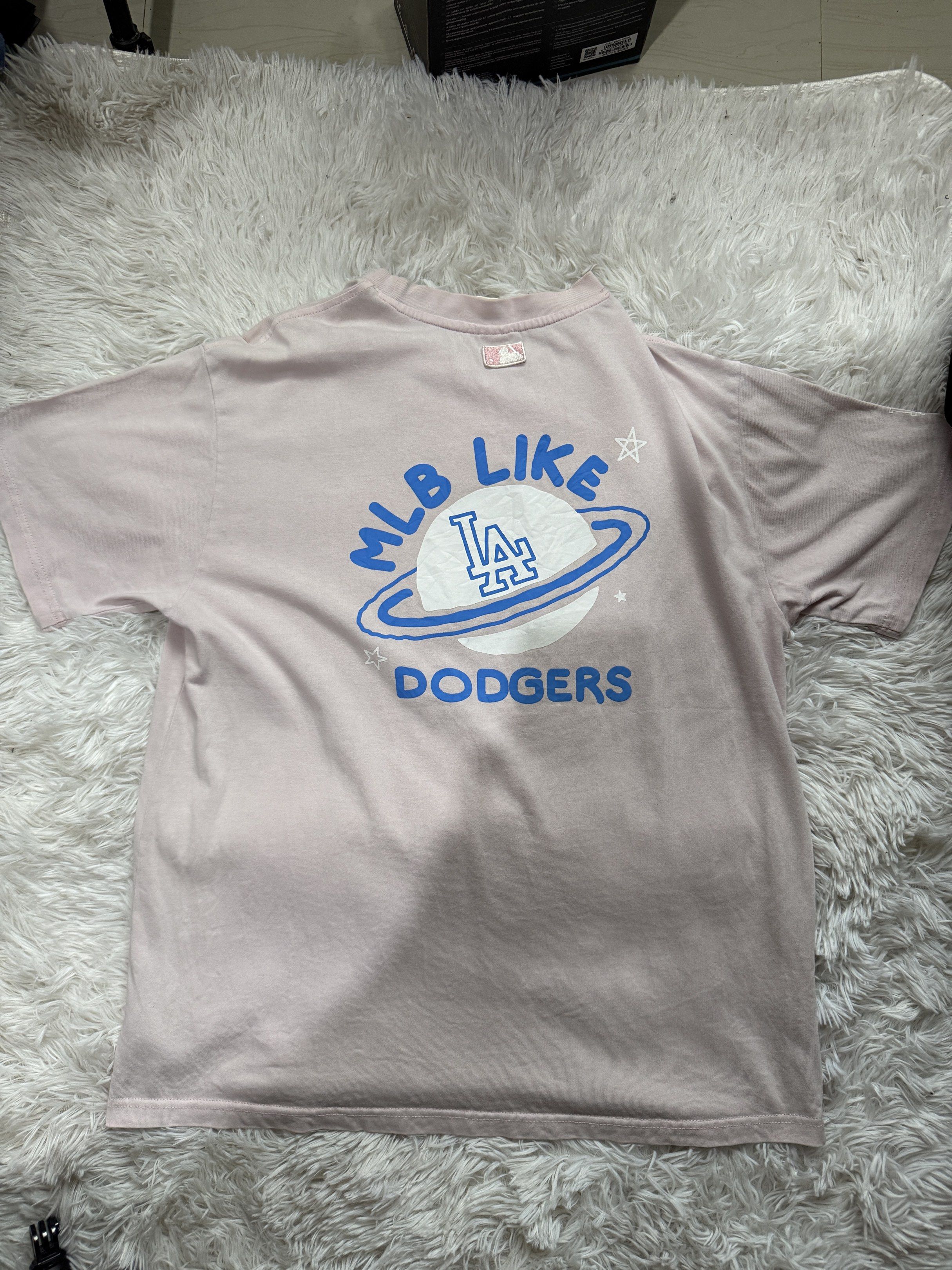 MLB Dodgers T-shirt (Category: Tshirts & Polo Shirts ) located in Manila. Submitted by keepercollection (Listing ID 1418210192, Image 2). Description: - Light pink MLB Dodgers T-shirt - Features the iconic LA logo - Eye-catching graphic design on the back - Comfortable crew neck design - Official MLB-licensed product - Made from soft, comfortable material.