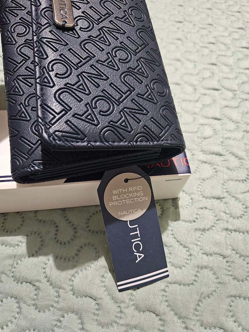 Nautica Navy Blue Wallet (Category: Wallets & Card holders) located in Manila. Submitted by closetcollection.ph (Listing ID 1418361343, Image 2). Description: - Brand new Nautica wallet - Navy blue color - Embossed Nautica logo - Multiple card slots - ID windows - Zippered compartment - RFID blocking protection - With original tags.