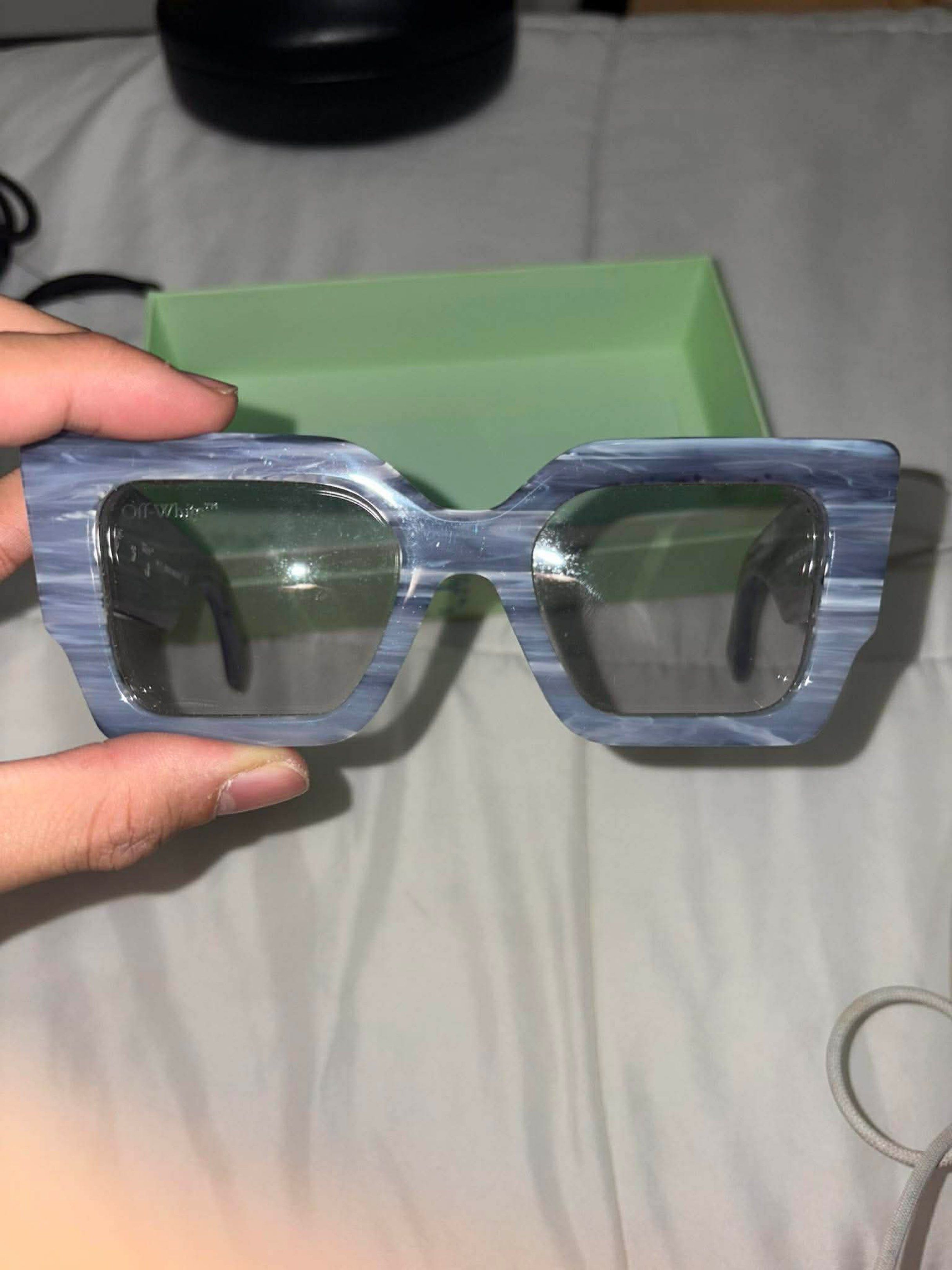 Off-White Sunglasses (Category: Sunglasses & Eyewear) located in Taguig. Submitted by homieplugph (Listing ID 1418356512, Image 1). Description: - Stylish Off-White sunglasses - Unique marbled blue frame - Off-White logo on lens - Signature arrow design on temples - Includes original box - Perfect for everyday wear.