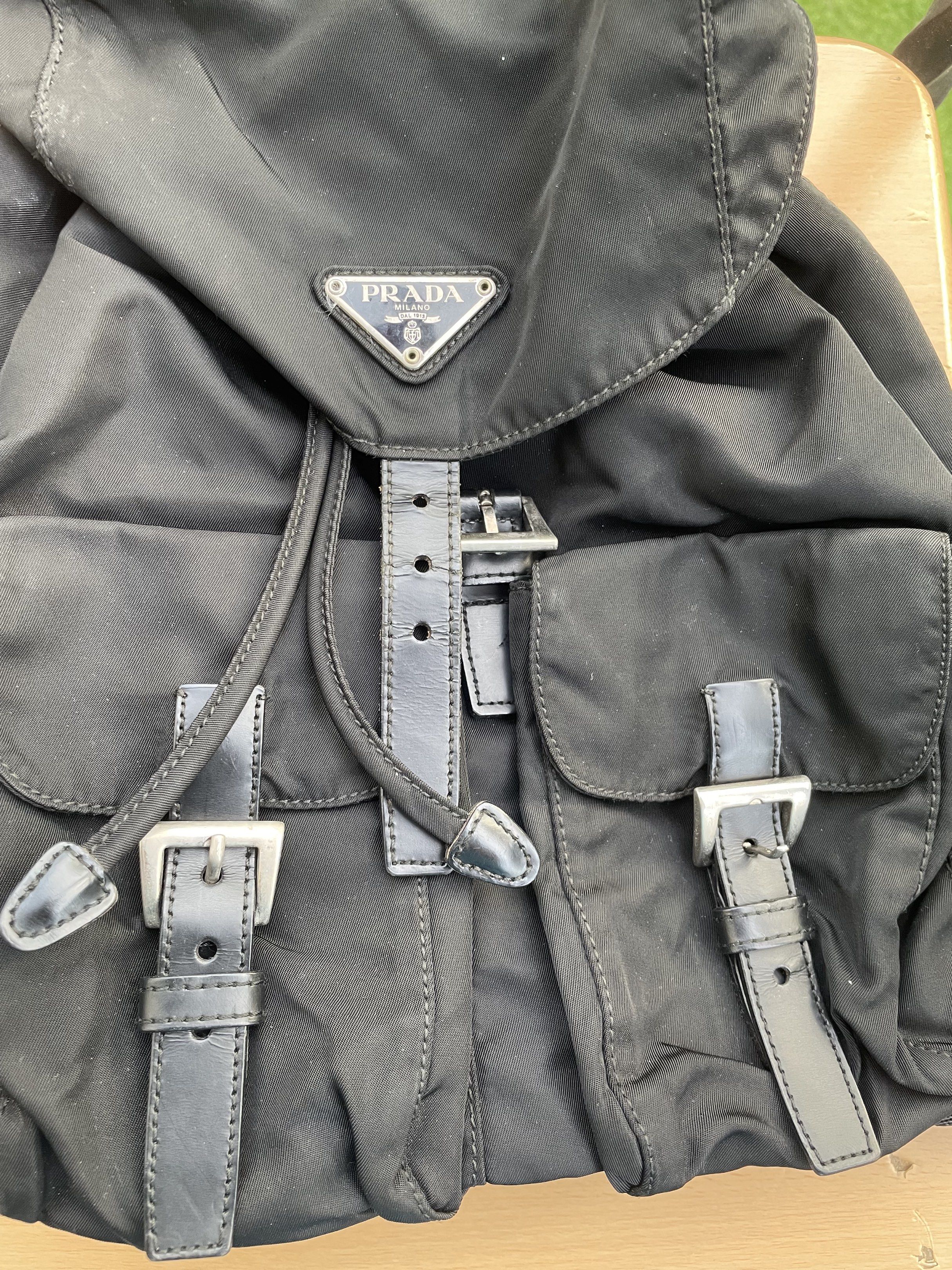 Prada Black Nylon Backpack (Category: Luxury Bags & Wallets) located in Makati City. Submitted by forbesclosetsale (Listing ID 1418305001, Image 3). Description: - Prada black nylon backpack - Flap closure with buckle details - Two front pockets - Adjustable shoulder straps - Drawstring closure - Interior zippered pocket - Prada branded tag - Classic design with Prada logo.