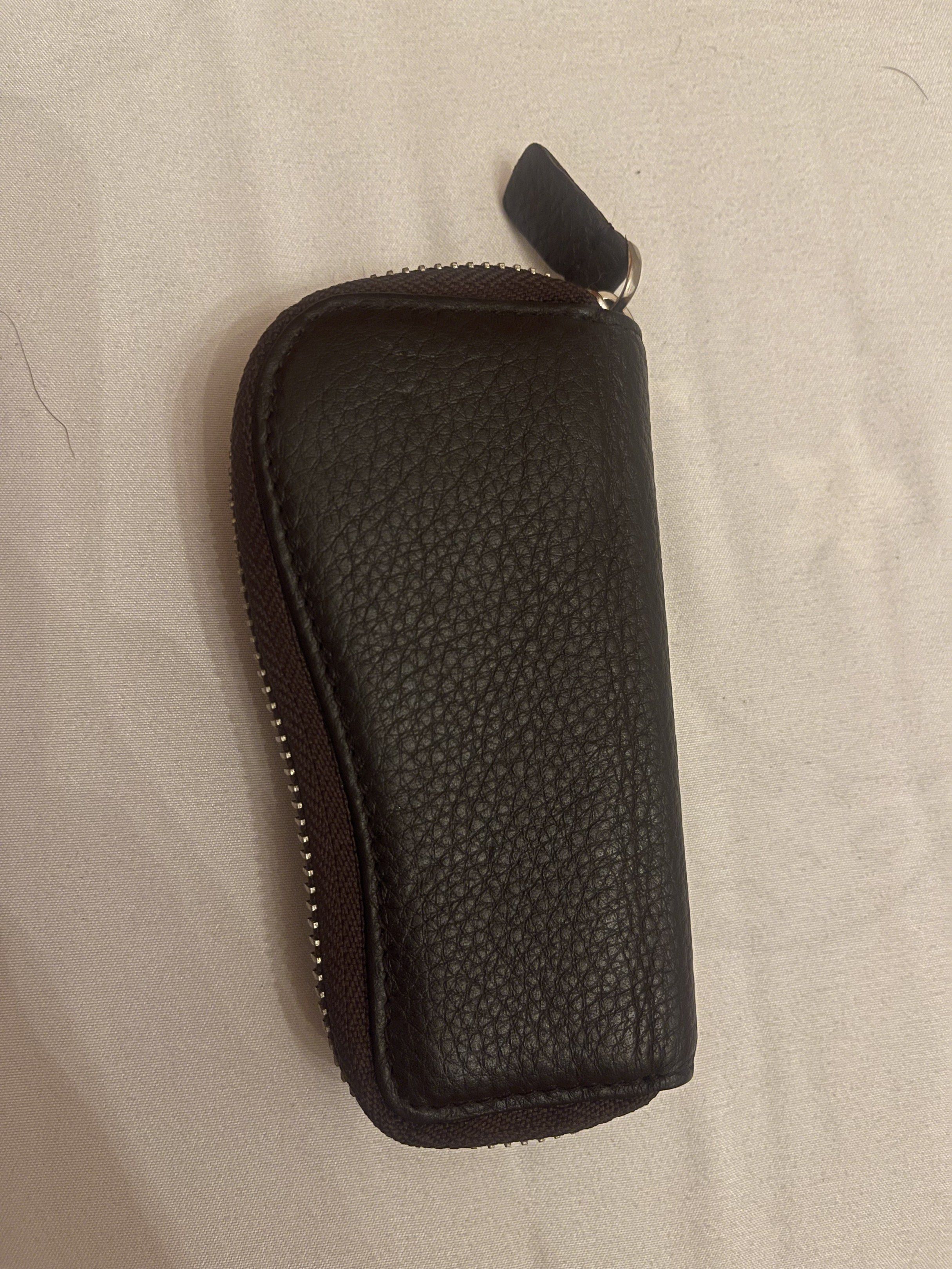 Prada Key Holder (Category: Luxury Bags & Wallets) located in Marilao. Submitted by wardrovearchives (Listing ID 1418308614, Image 2). Description: Authentic Prada leather key case sourced from a reputable Japanese preloved store. Made from soft pebbled leather with a classic zip-around design and 6-key hooks. Details: • Brand: Prada • Material: Genuine leather • Color: Dark brown • Closure: Zip-around • Interior: 6 key hooks • Made in Italy (as 