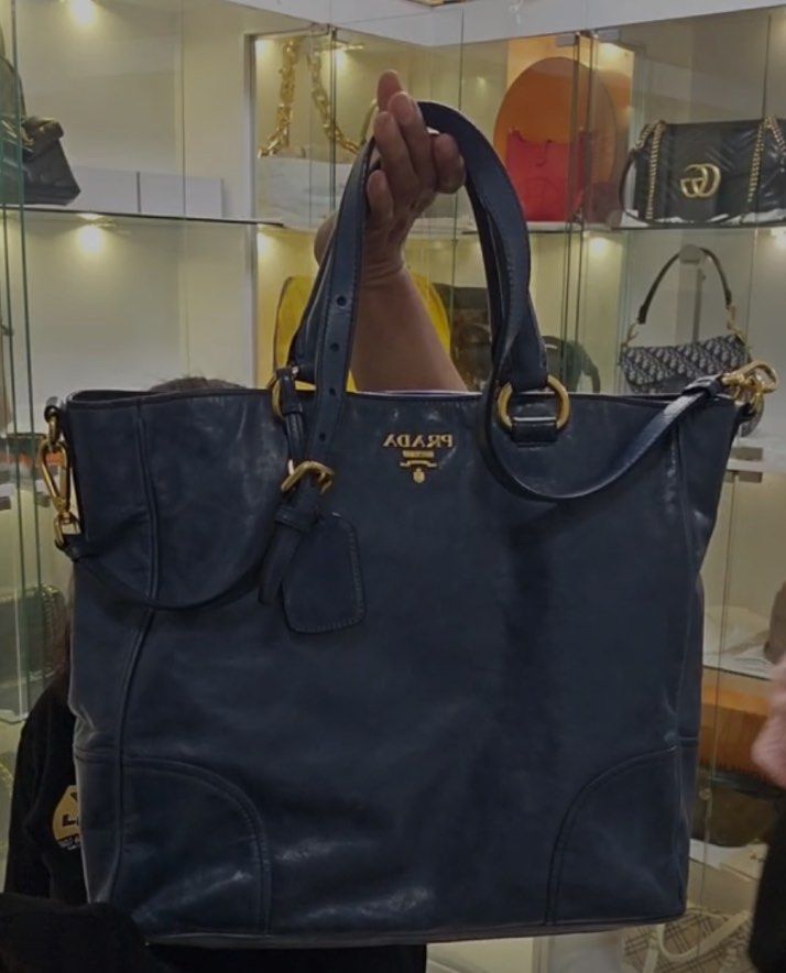 Prada Leather Tote Bag (Category: Luxury Bags & Wallets) located in Paranaque City. Submitted by sctmpque (Listing ID 1418394172, Image 1). Description: - Navy blue Prada tote bag - Gold-tone hardware - Includes detachable luggage tag - Interior zippered pocket - Double handles and shoulder strap - Prada logo on front SF c/o Buyer.