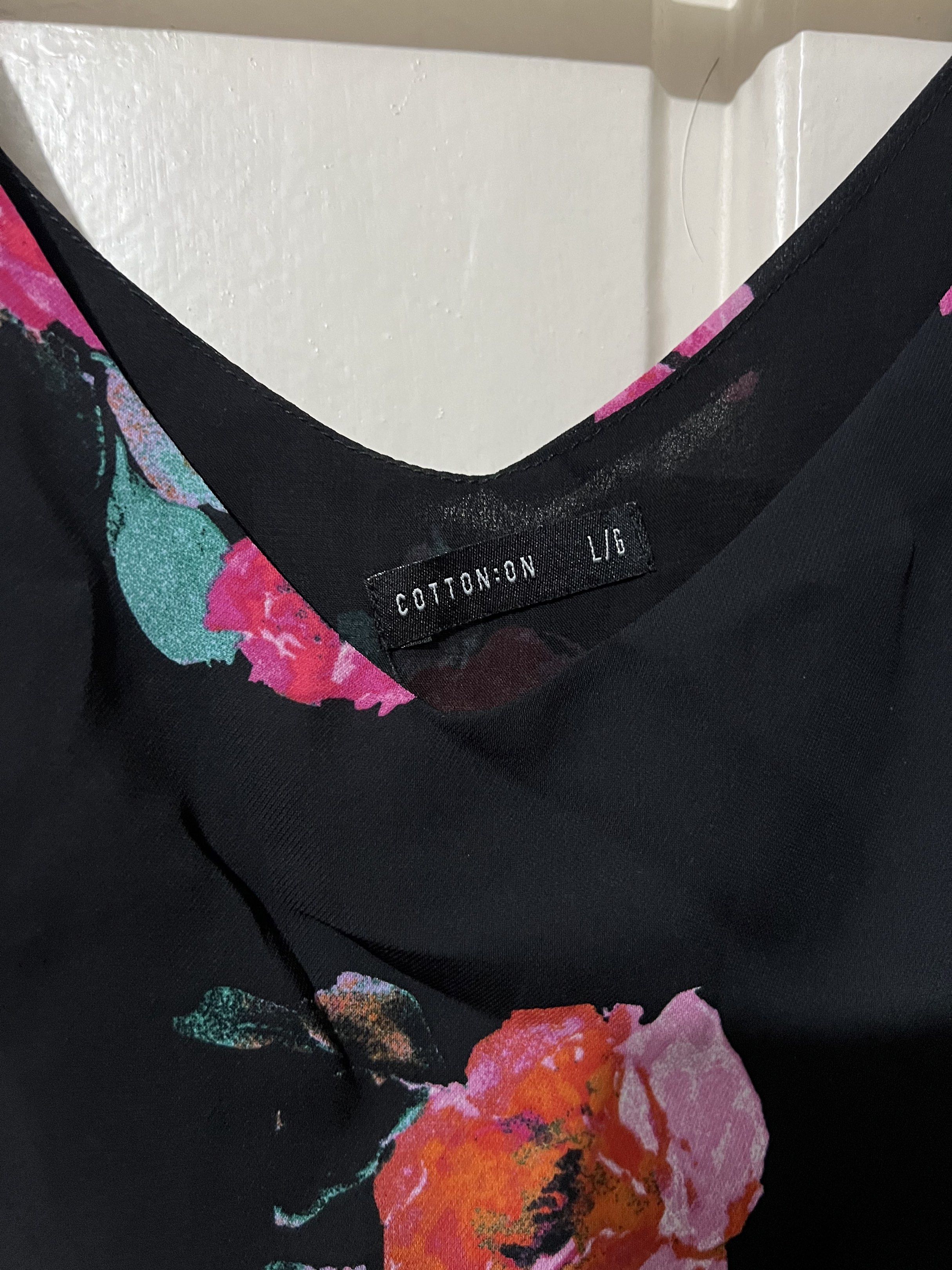 Preloved Cotton On Floral Cami Top (Category: Sleeveless) located in Binan City. Submitted by unicohijoxfudge (Listing ID 1418312638, Image 2). Description: Decluttering❤️❤️❤️ Size L 21” width x 22” length Black cami top from Cotton On with a floral print. Features adjustable straps and a V-neckline. The size is L/G. The top is made of a lightweight material, perfect for warm weather. It has a flowy silhouette and is suitable for casual wear. ✅SF