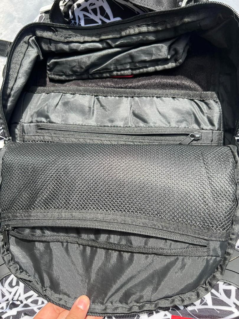 Sprayground Black Book Backpack Brand New (Category: Backpacks) located in Lipa City. Submitted by wewez_store (Listing ID 1418332794, Image 3). Description: - Sprayground backpack with a unique black and white design. - Features a bold shark mouth design on the front. - Includes a "BLACK BOOK" label area. - Equipped with a top handle and adjustable straps for comfort. - Features the Sprayground logo on the bottom right..