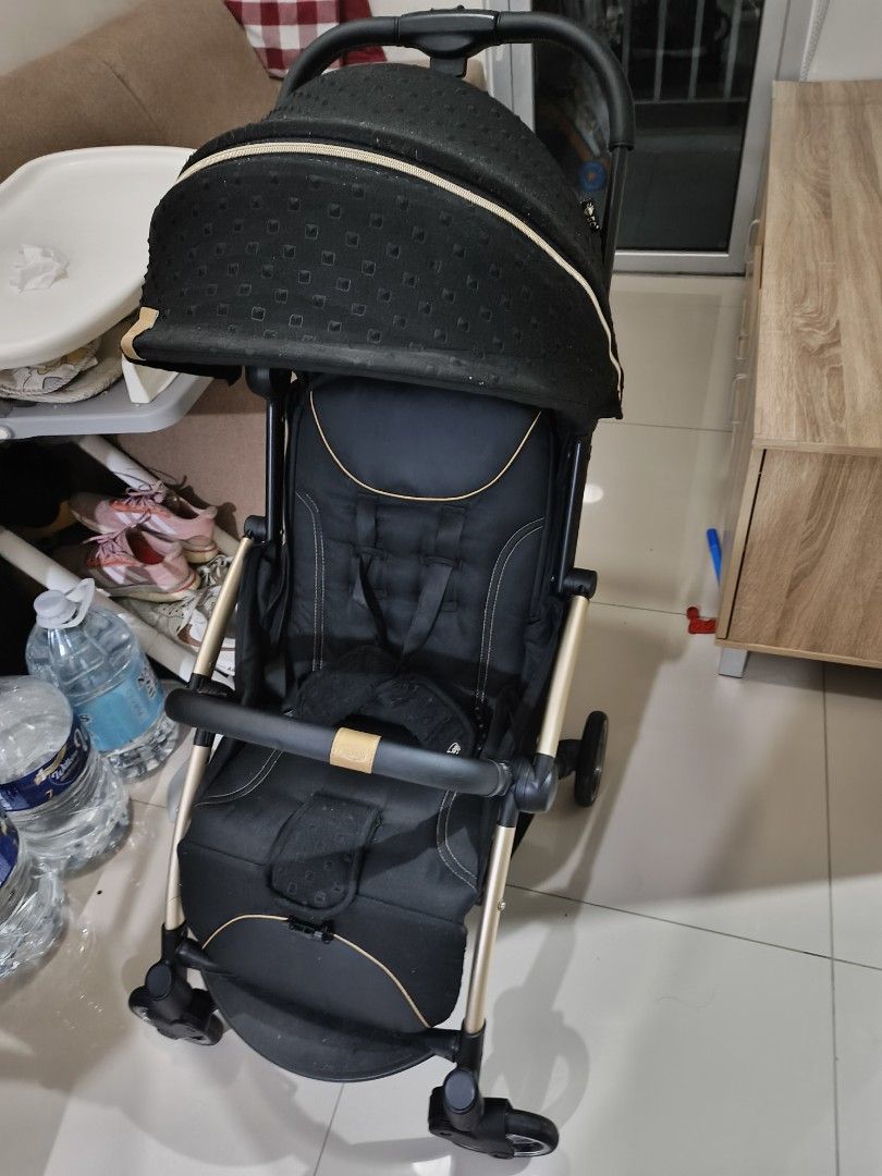 Stroller (Chico brand) (Category: Strollers) located in Cainta. Submitted by inozone (Listing ID 1418321828, Image 1). Description: Stroller features a sleek black design with gold accents. It has a canopy for sun protection and a comfortable seat with a safety harness. It has a handle for pushing and wheels for smooth movement..