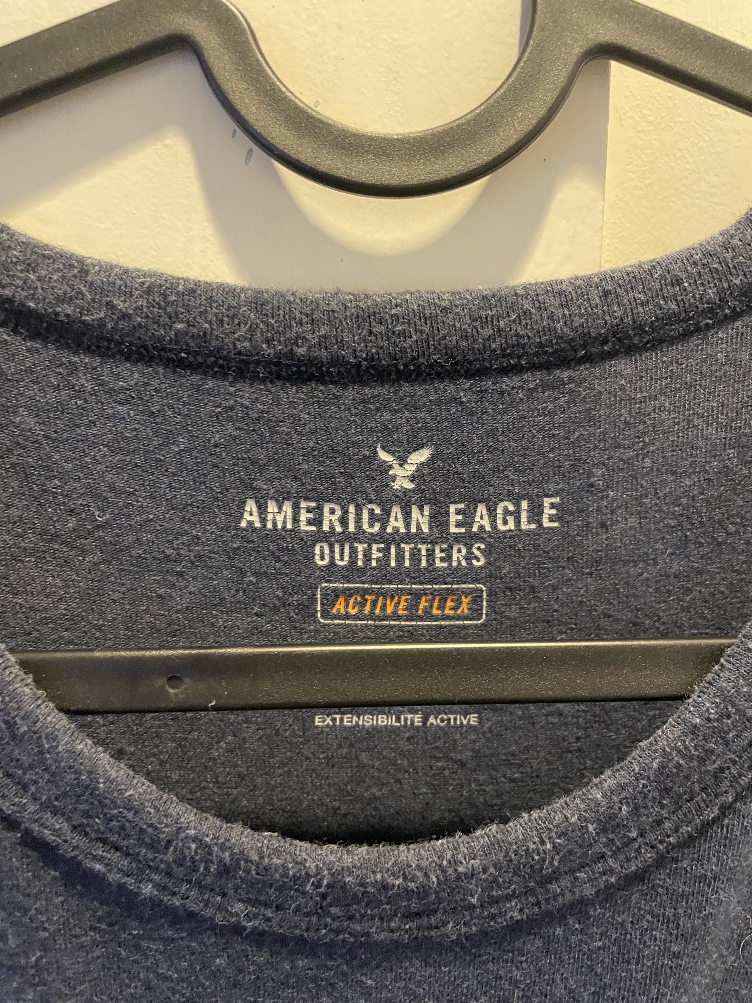 American Eagle Outfitters Active Flex T-shirt (Category: Tshirts & Polo Shirts ) located in Las Pinas. Submitted by bmtl_ (Listing ID 1418526315, Image 2). Description: American Eagle Outfitters Active Flex T-shirt. Features a navy blue base with pink and white horizontal stripes across the chest. Made in Vietnam. Size S/P/CH. The shirt has a crew neck and short sleeves..