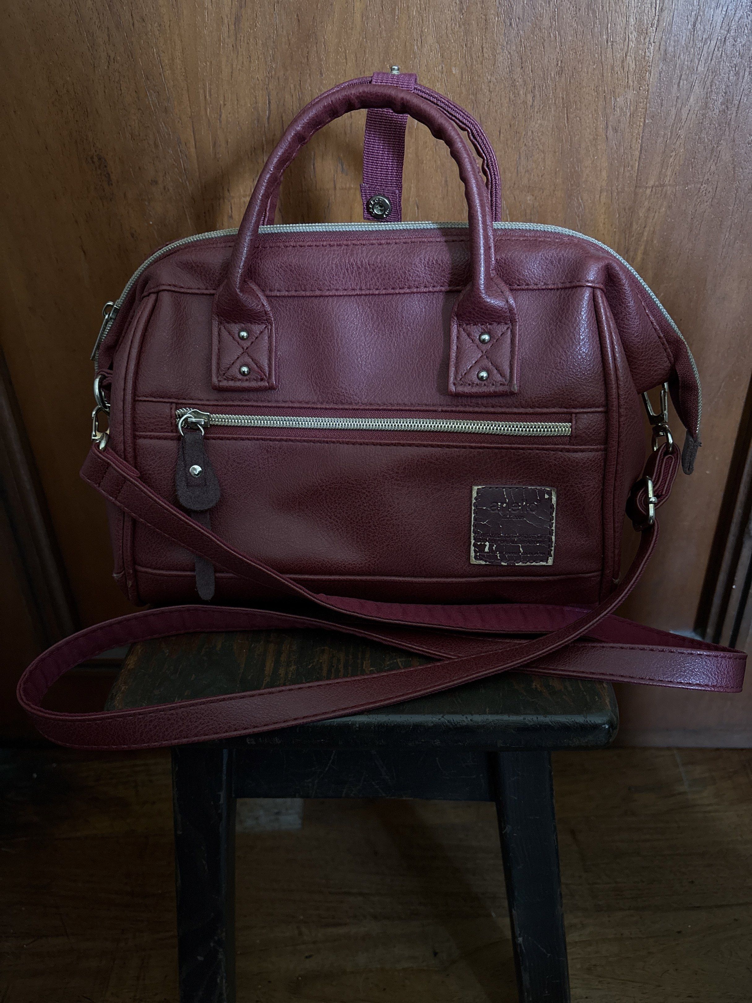 anello Red Maroon Shoulder Bag with Top Handle (Category: Shoulder Bags) located in Taguig. Submitted by rdwayusa (Listing ID 1418427077, Image 1). Description: - Maroon shoulder bag - Top handle and detachable strap - Front zipper pocket - Small tag detail - Rectangular shape - Structured design - Leather-like material - Silver-colored hardware.