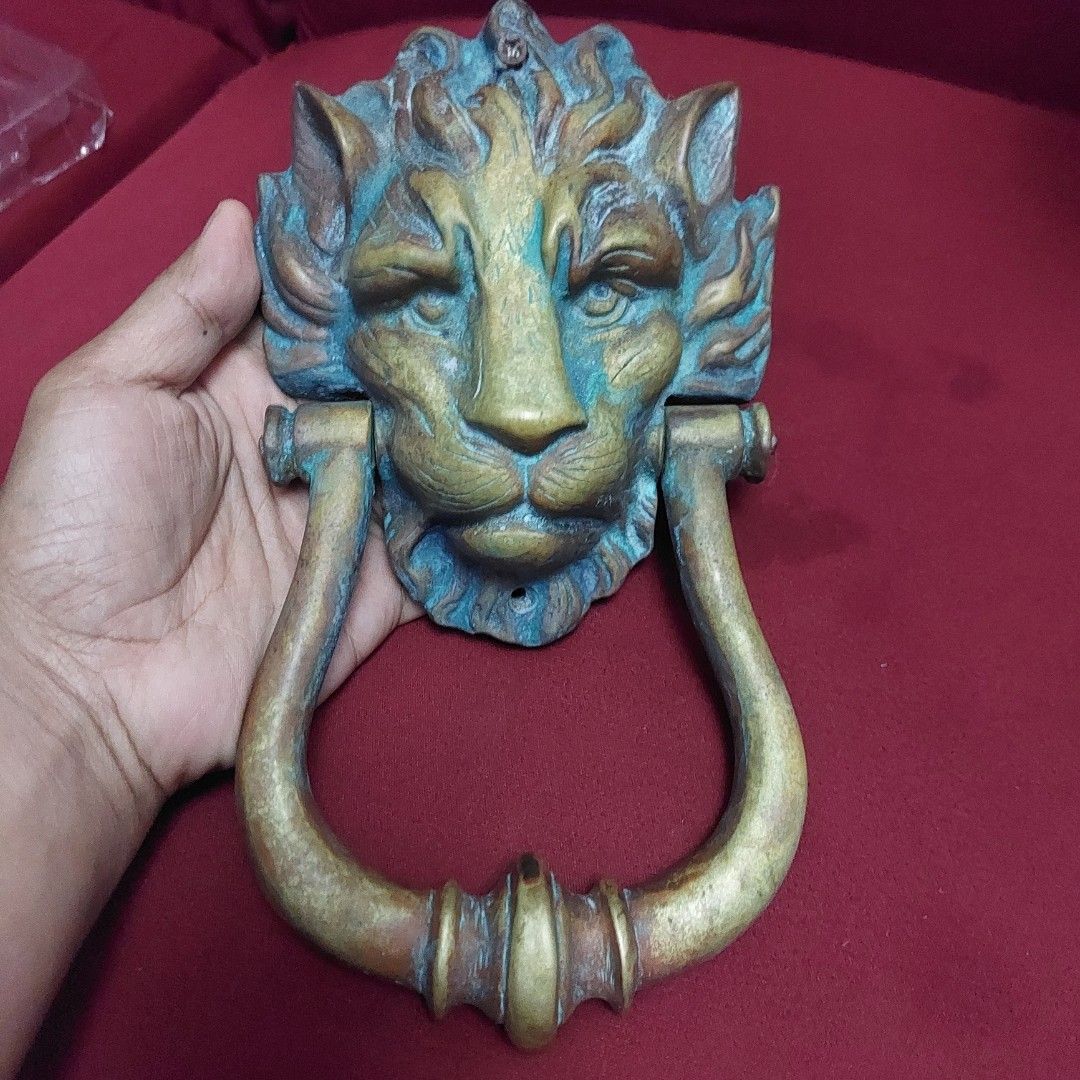 Antique Lion Head Door Knocker (Category: Vintage Collectibles) located in Pasig City. Submitted by carls_vintages (Listing ID 1418501437, Image 1). Description: - Antique-style door knocker - Features a detailed lion head design - Brass finish with patina - Weighs approximately 184 grams - Curved handle - Includes mounting holes.