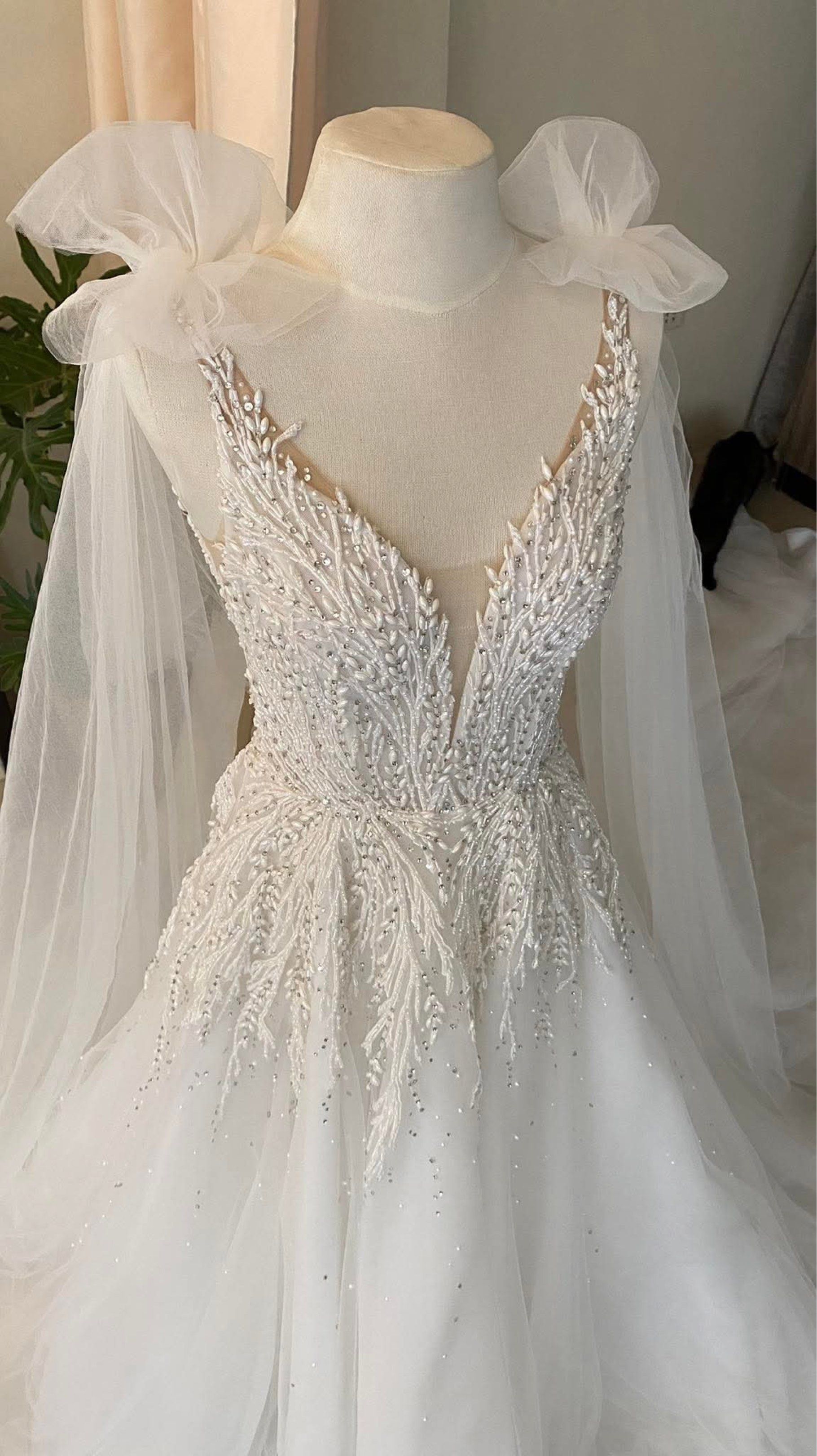Elegant White Wedding Gown with Cape (Category: Evening dresses & gowns) located in Lipa City. Submitted by lvthrift (Listing ID 1418538183, Image 2). Description: - White wedding gown - Intricate beadwork on bodice - Flowing tulle skirt - Delicate cape detail - Deep V-neckline - Low back - Perfect for a romantic and sophisticated bride.