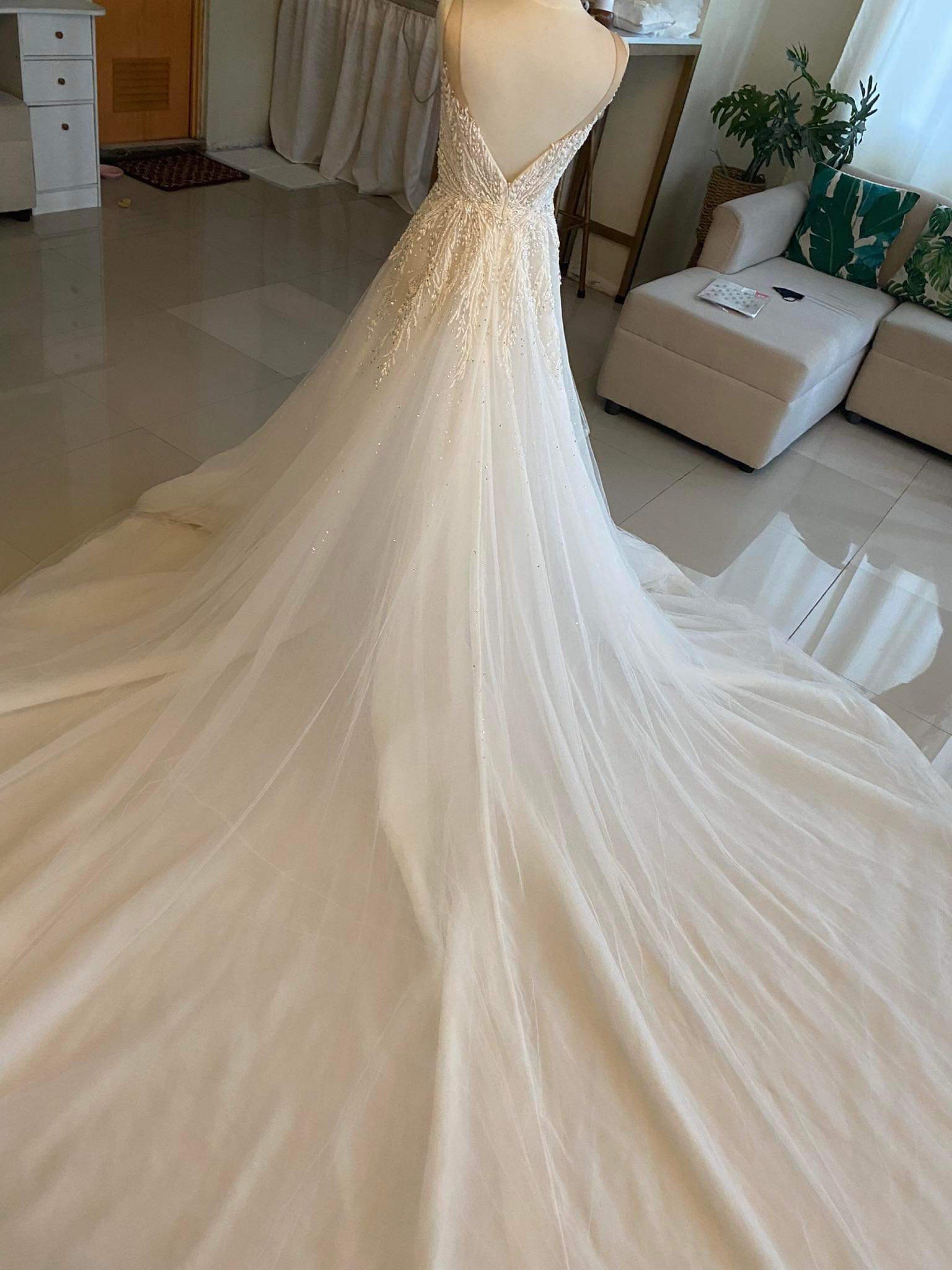 Elegant White Wedding Gown with Cape (Category: Evening dresses & gowns) located in Lipa City. Submitted by lvthrift (Listing ID 1418538183, Image 3). Description: - White wedding gown - Intricate beadwork on bodice - Flowing tulle skirt - Delicate cape detail - Deep V-neckline - Low back - Perfect for a romantic and sophisticated bride.