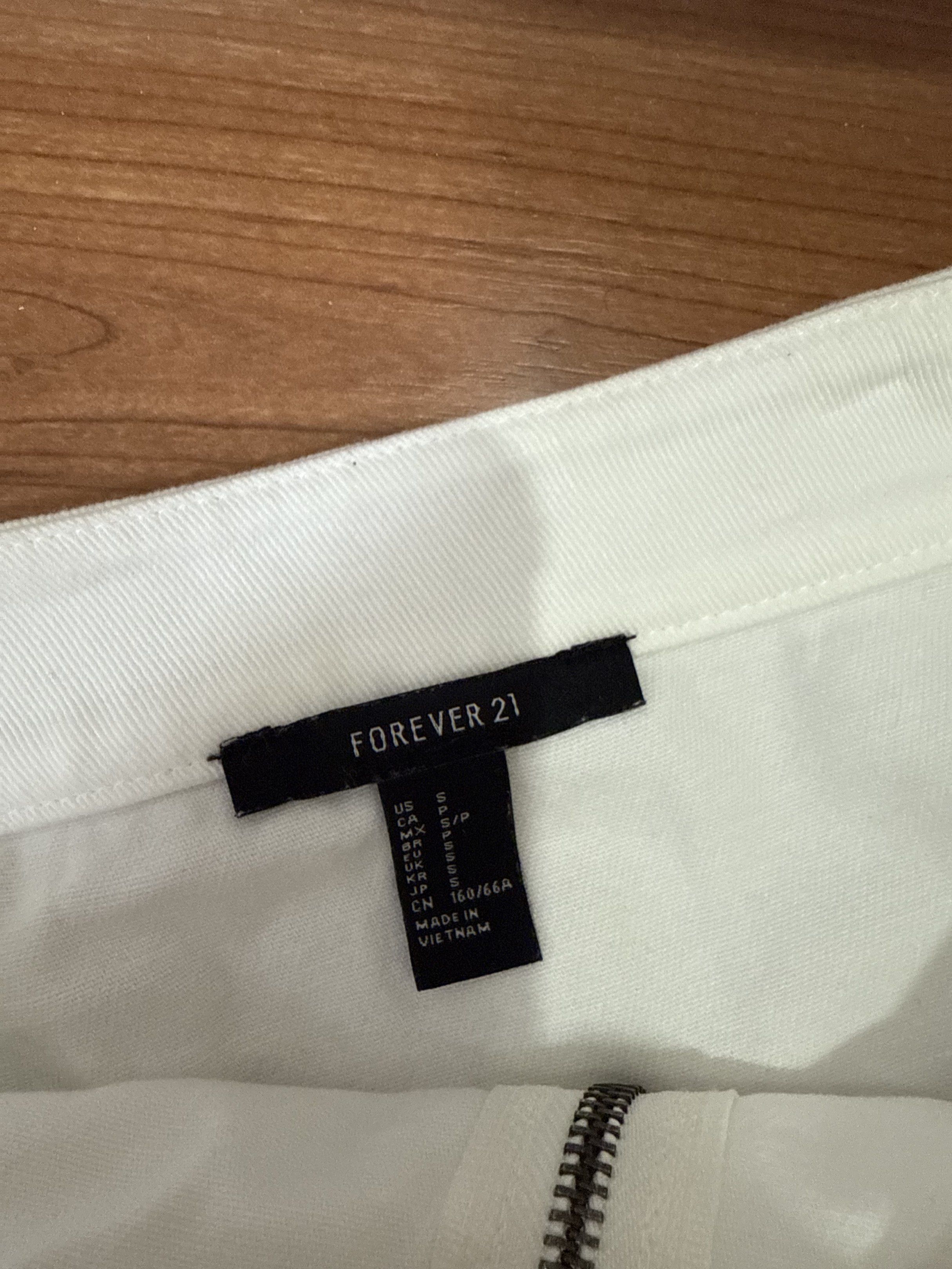 Forever 21 White Denim Mini Skirt (Category: Skirts) located in Las Pinas. Submitted by kva13 (Listing ID 1418426655, Image 3). Description: - Forever 21 mini skirt - White color - Size: S - Front zipper closure - Made in Vietnam.