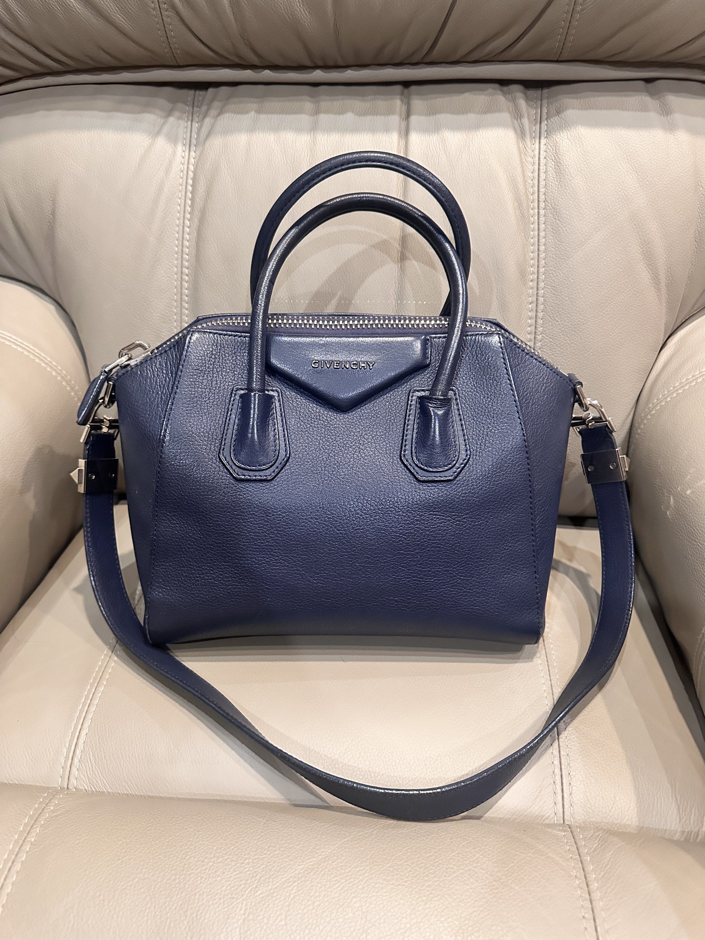 Givenchy Antigona Small Handbag (Category: Luxury Bags & Wallets) located in Koronadal. Submitted by andreamichelle75 (Listing ID 1418506047, Image 1). Description: -Well used small Givenchy Antigona in navy blue -Inclusion: dust bag -With normal signs of usage -Clean interior -Can be worn as shoulder bag.