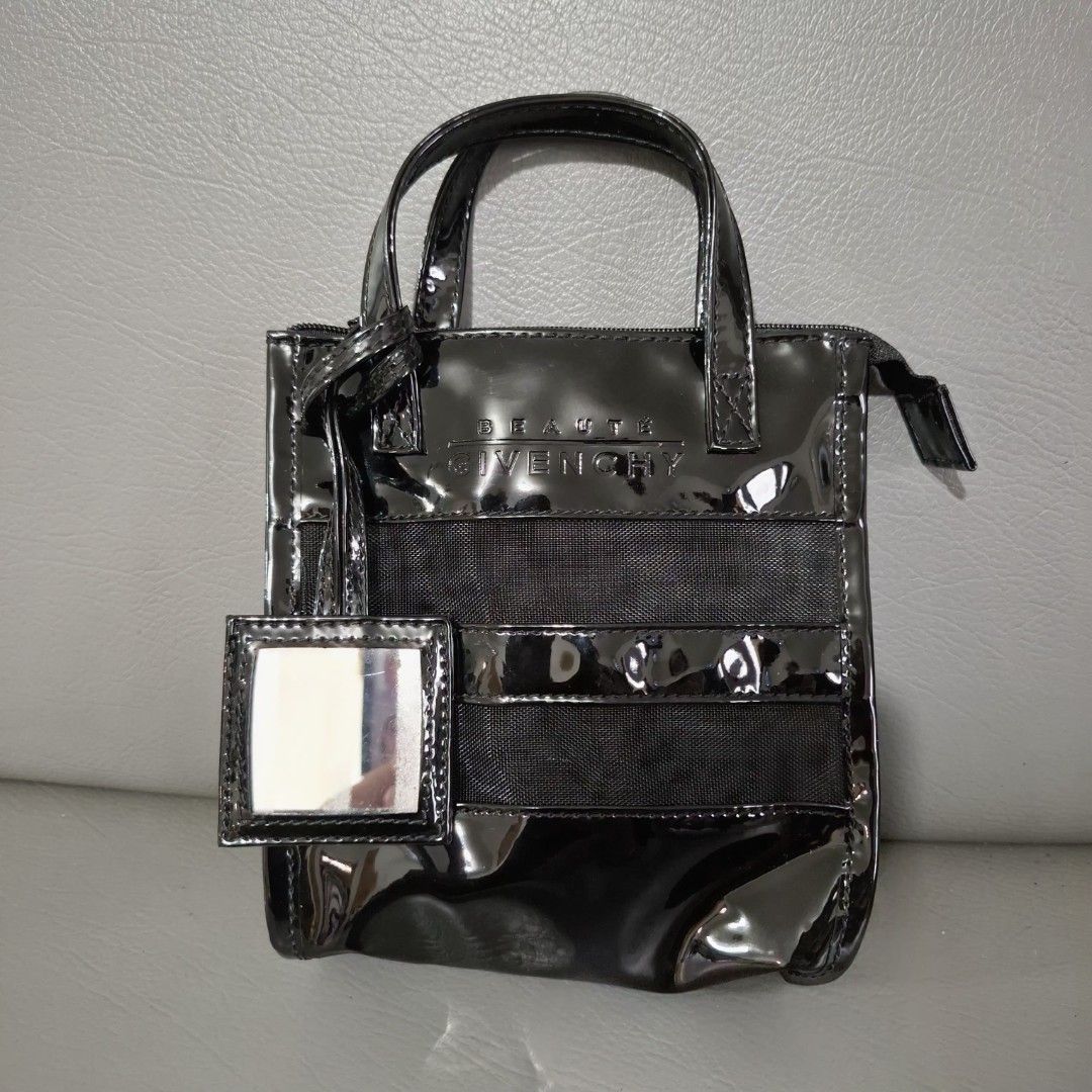 Givenchy Beauté Black Handbag (Category: Luxury Bags & Wallets) located in Don Carlos. Submitted by PphiXi_Finds (Listing ID 1418444508, Image 1). Description: - Black Givenchy Beauté cute or small handbag - Glossy finish with mesh panel - Includes a small mirror tag - Top zipper closure - Two handles - Black interior - Givenchy Beauté logo visible.